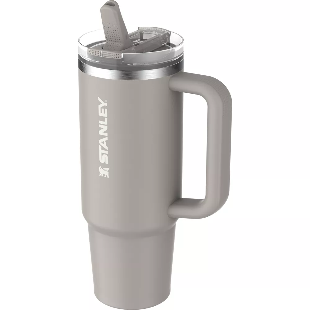 Grauer Stanley-Becher mit Henkel und durchsichtigem Deckel mit Strohhalmöffnung.