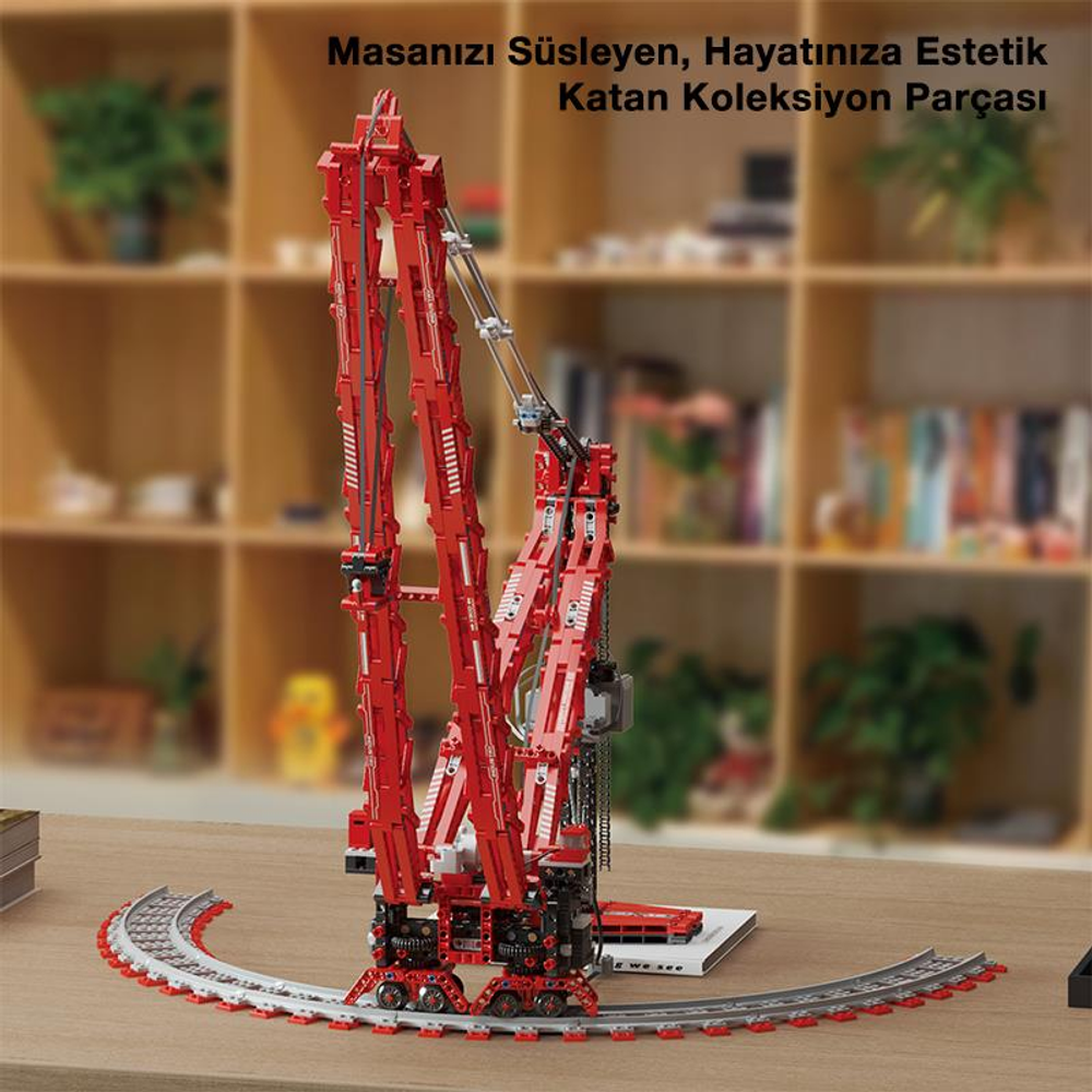 Bulanık bir kitaplığın önünde raylar üzerinde kırmızı vinç modeli.