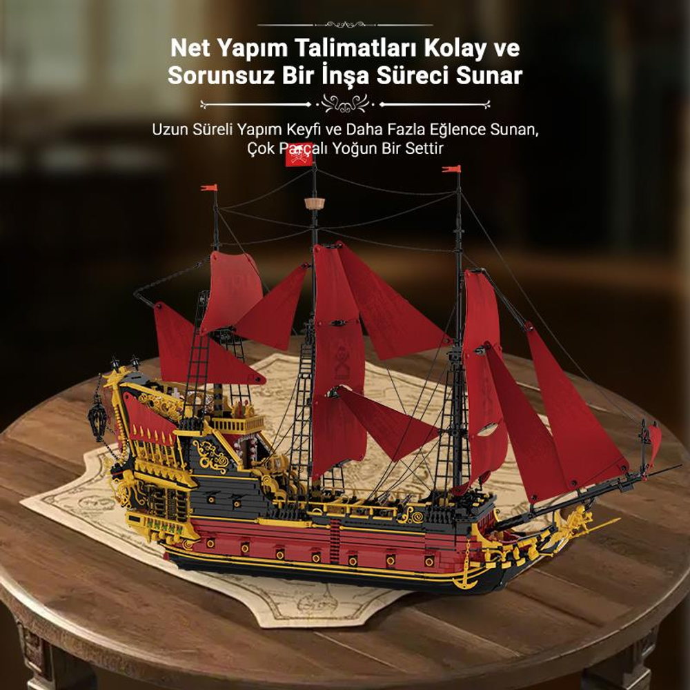 Kırmızı yelkenli detaylı bir korsan gemisi modeli, ahşap masa üzerinde sergileniyor.