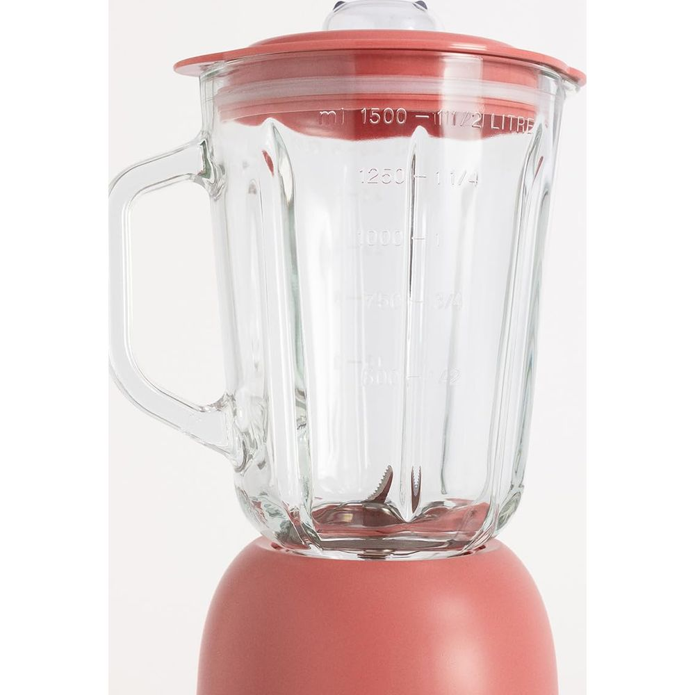 Eine Nahaufnahme eines roten Mixers mit Glasbehälter und Messskala.