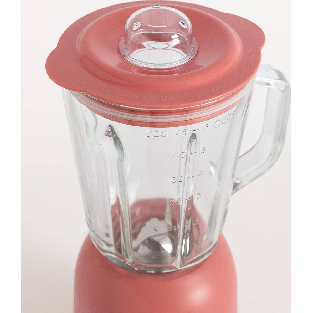 Ein rosafarbener Mixer mit Glasbehälter und Messskala.