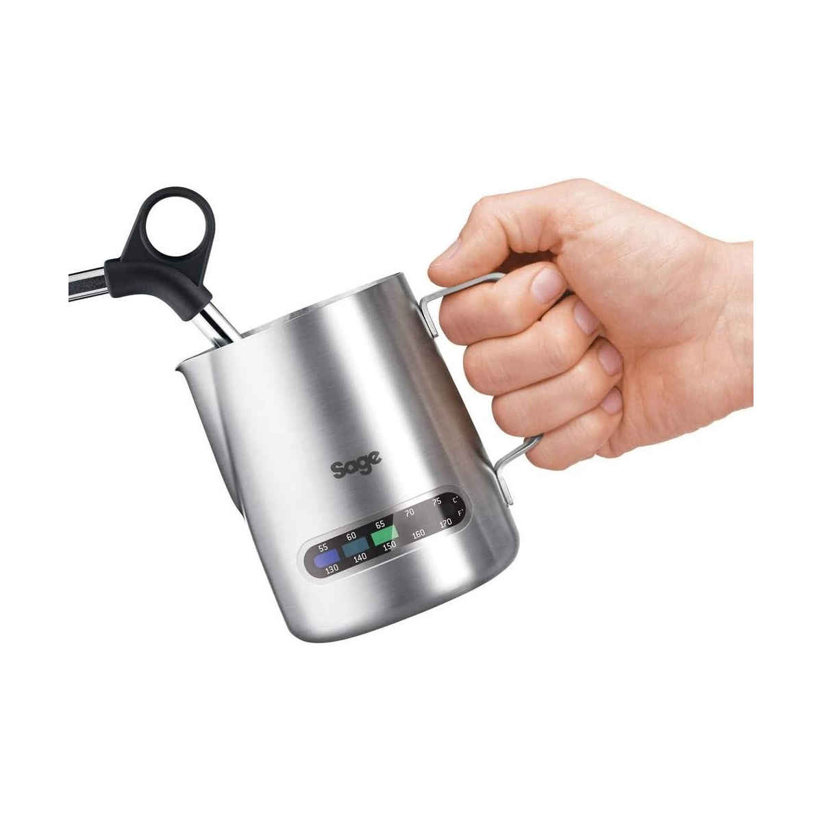 A hand holds a stainless steel Sage milk frothing pitcher with a thermometer.
