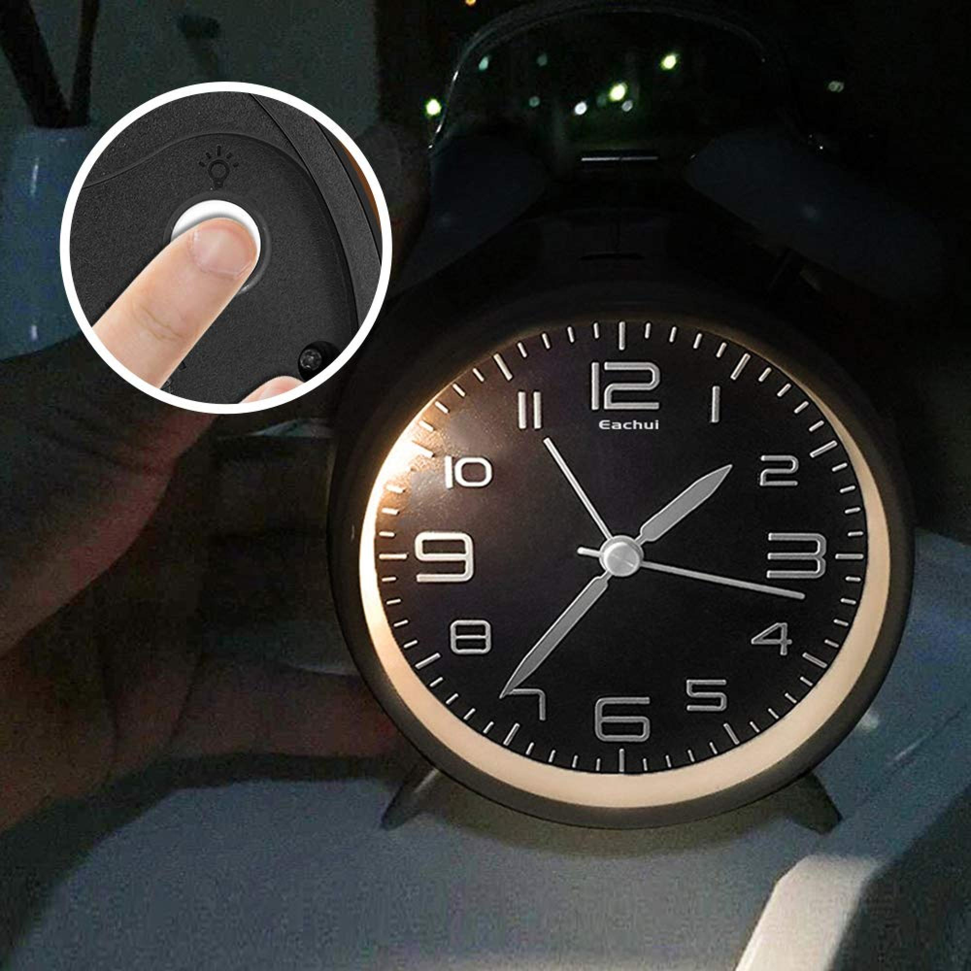 Eine Hand drückt auf die Licht-Taste eines schwarzen Weckers. Die Uhrzeit ist 1:52.