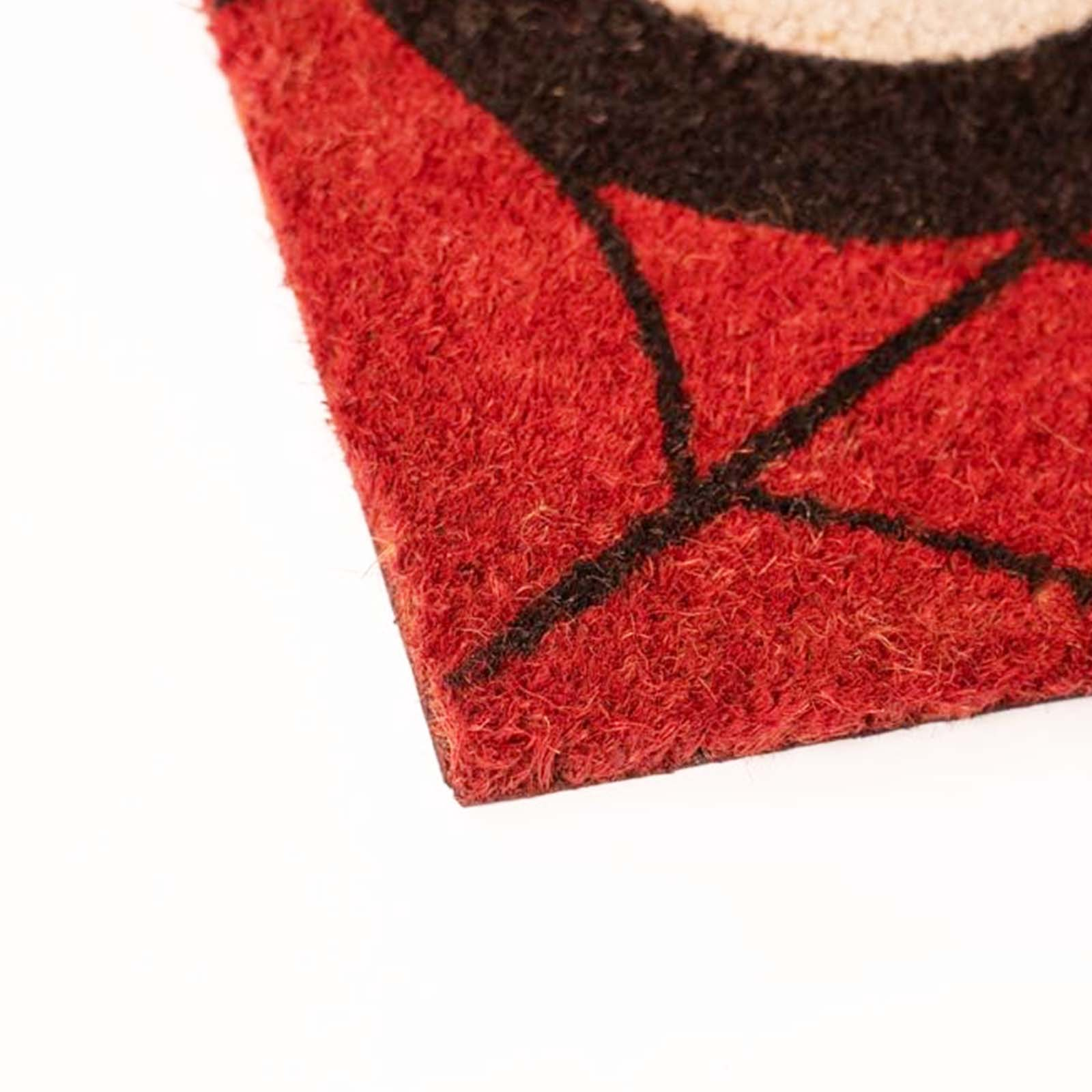 Primo piano di un tappeto rosso con linee nere su sfondo bianco.