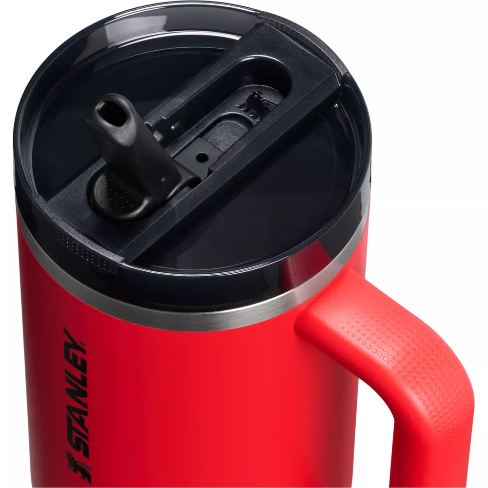 Siyah kapaklı ve pipet tutacaklı kırmızı Stanley kupa.