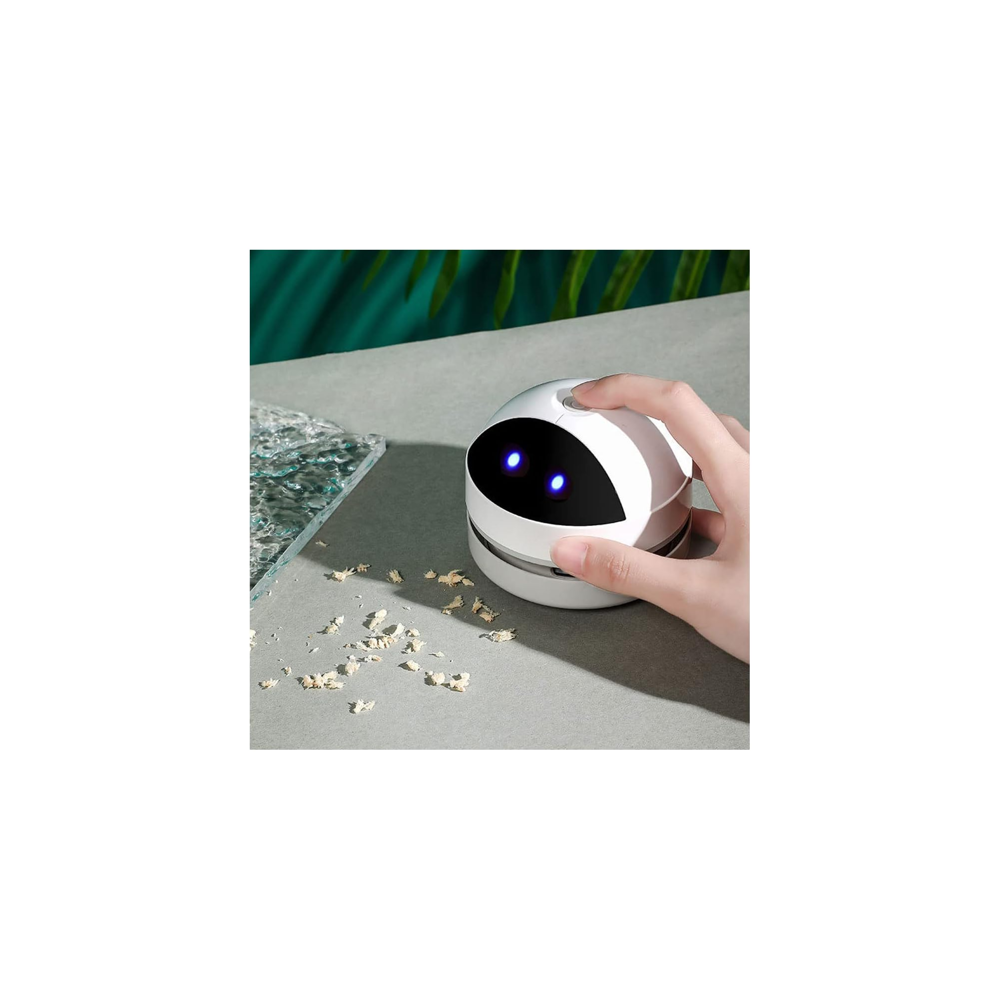 Eine weiße Tischreinigungsbürste mit blauen Lichtern wird von einer Hand gehalten.