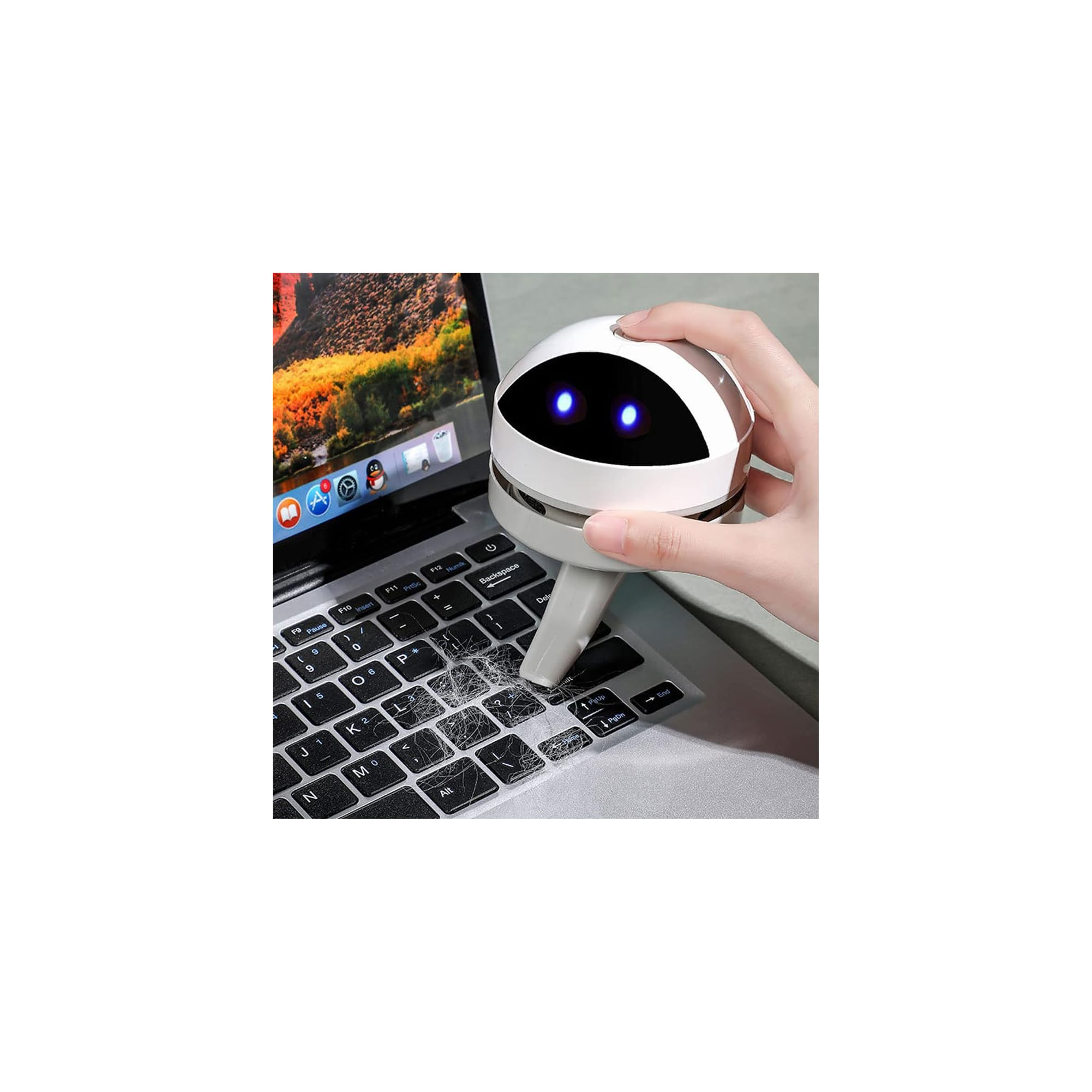 Ein kleiner Roboter-Staubsauger reinigt eine Tastatur mit Haaren und Staub.