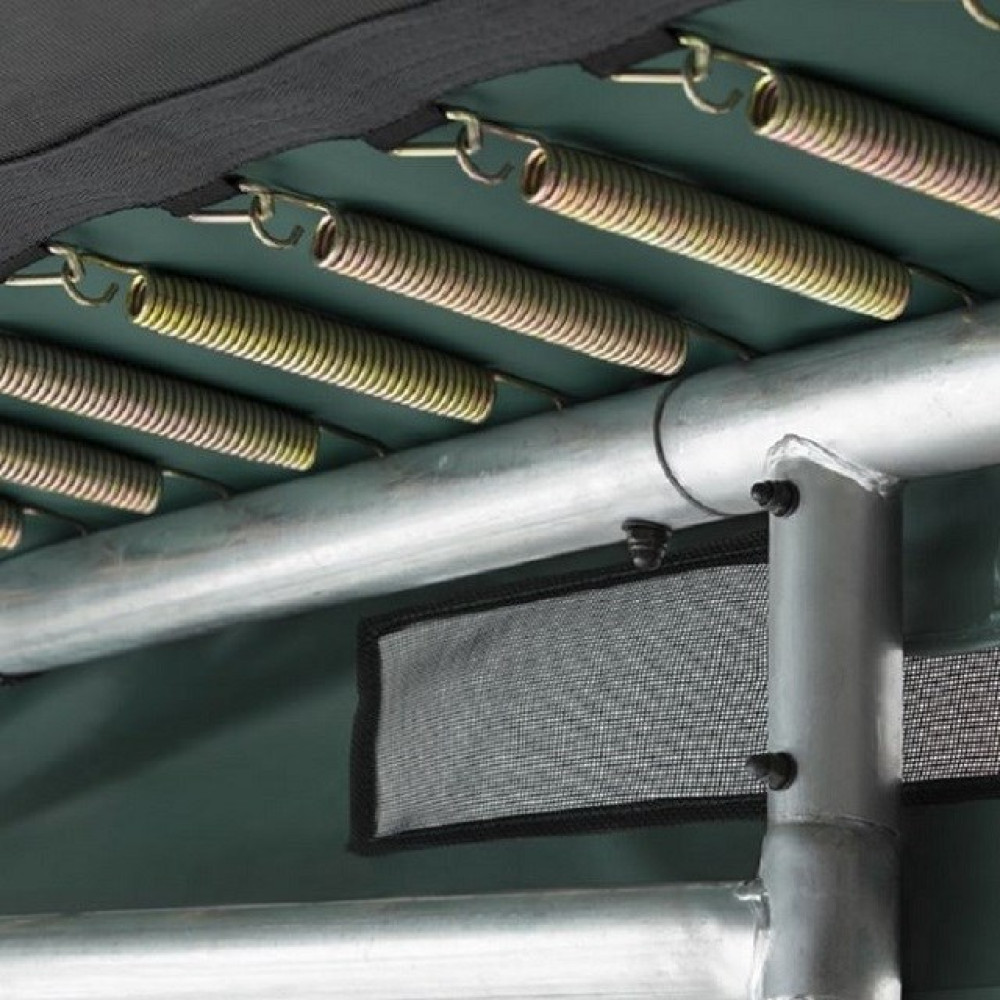 Metalowe sprężyny trampoliny z zielonym podkładem i srebrną metalową ramą.
