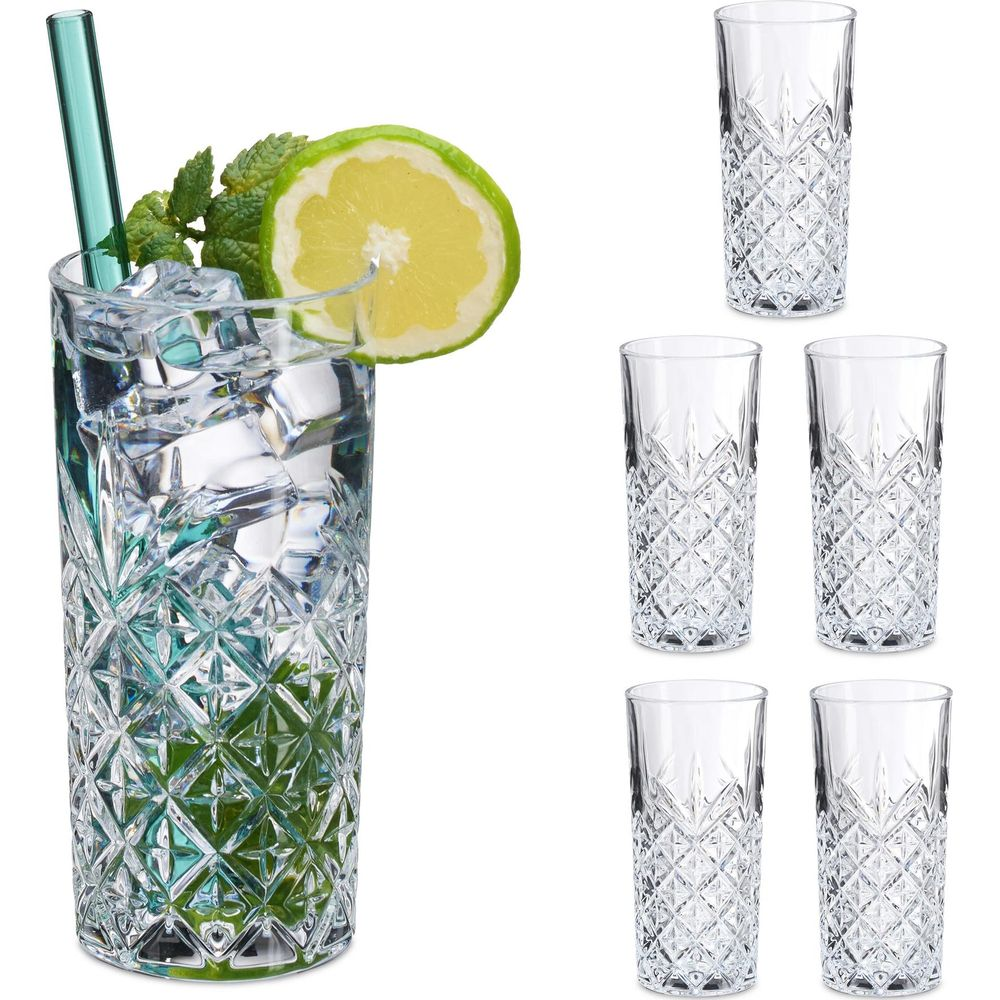 Ein Glas mit Eiswürfeln, Limette und Minze neben vier leeren Gläsern.