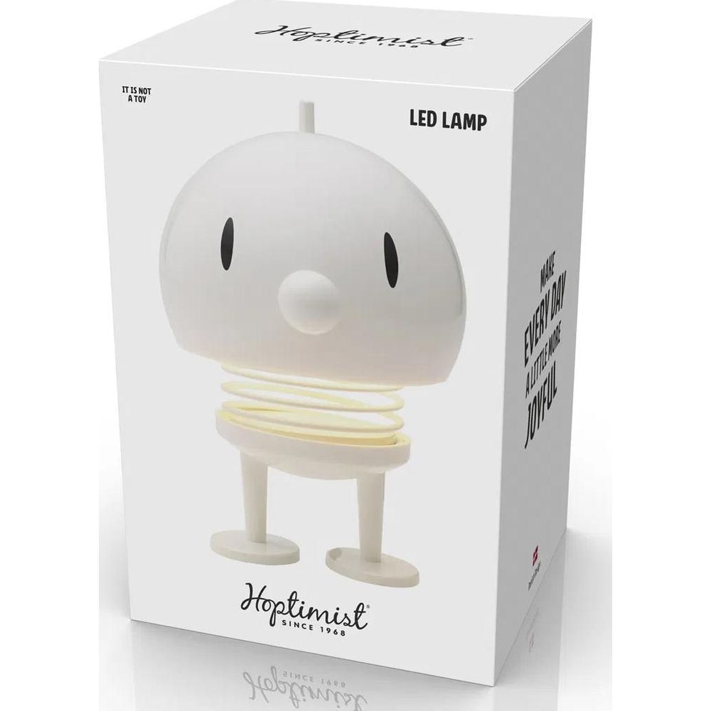 Emballage blanc avec une lampe LED blanche en forme de personnage avec un ressort.