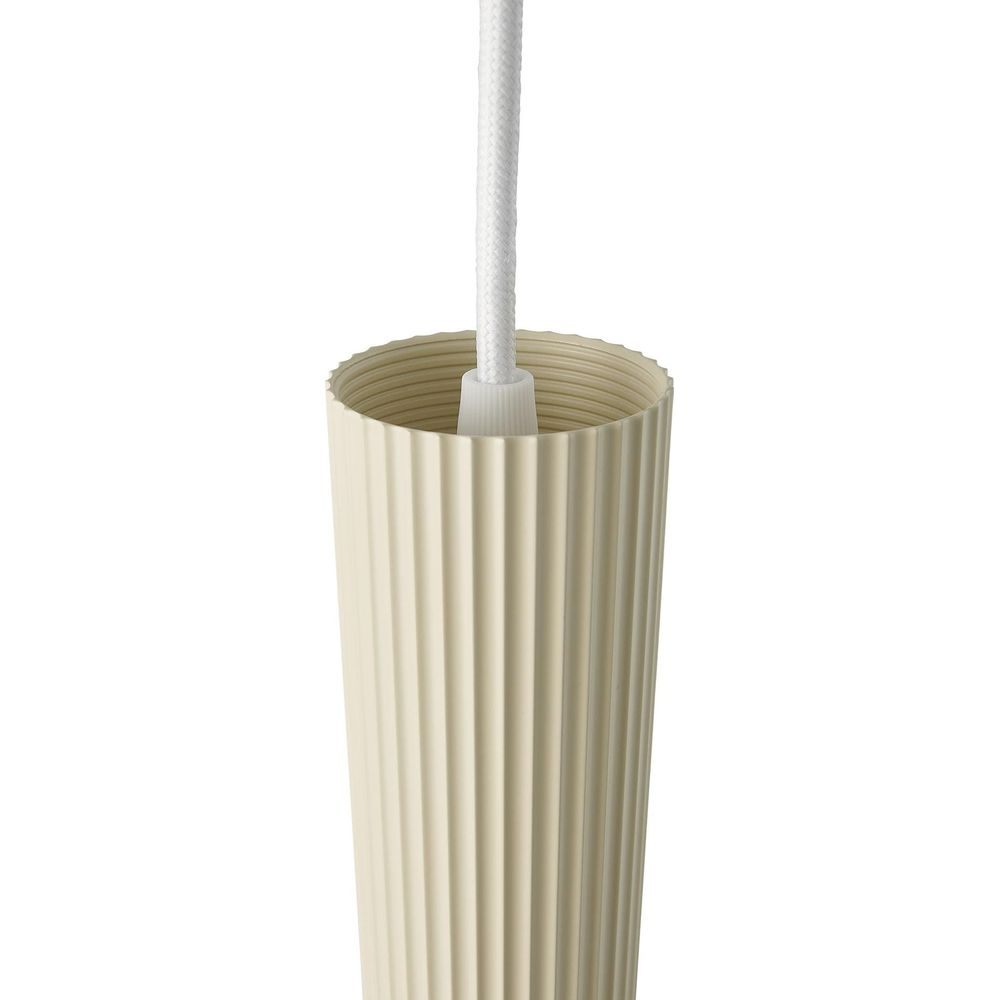 Un cordon de lampe couleur crème avec des rainures verticales et une corde blanche.