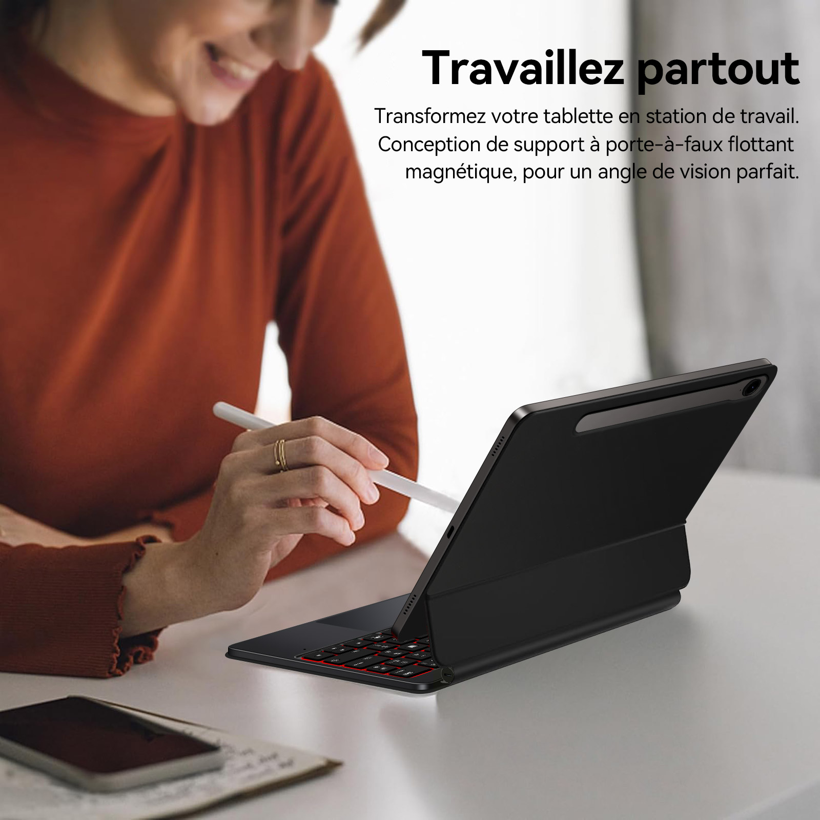 Eine Frau mit orangenem Pullover benutzt ein Tablet mit Tastatur und Stift.