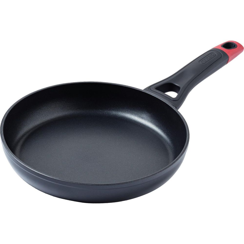 Poêle noire avec manche noir et accent rouge à l'extrémité.