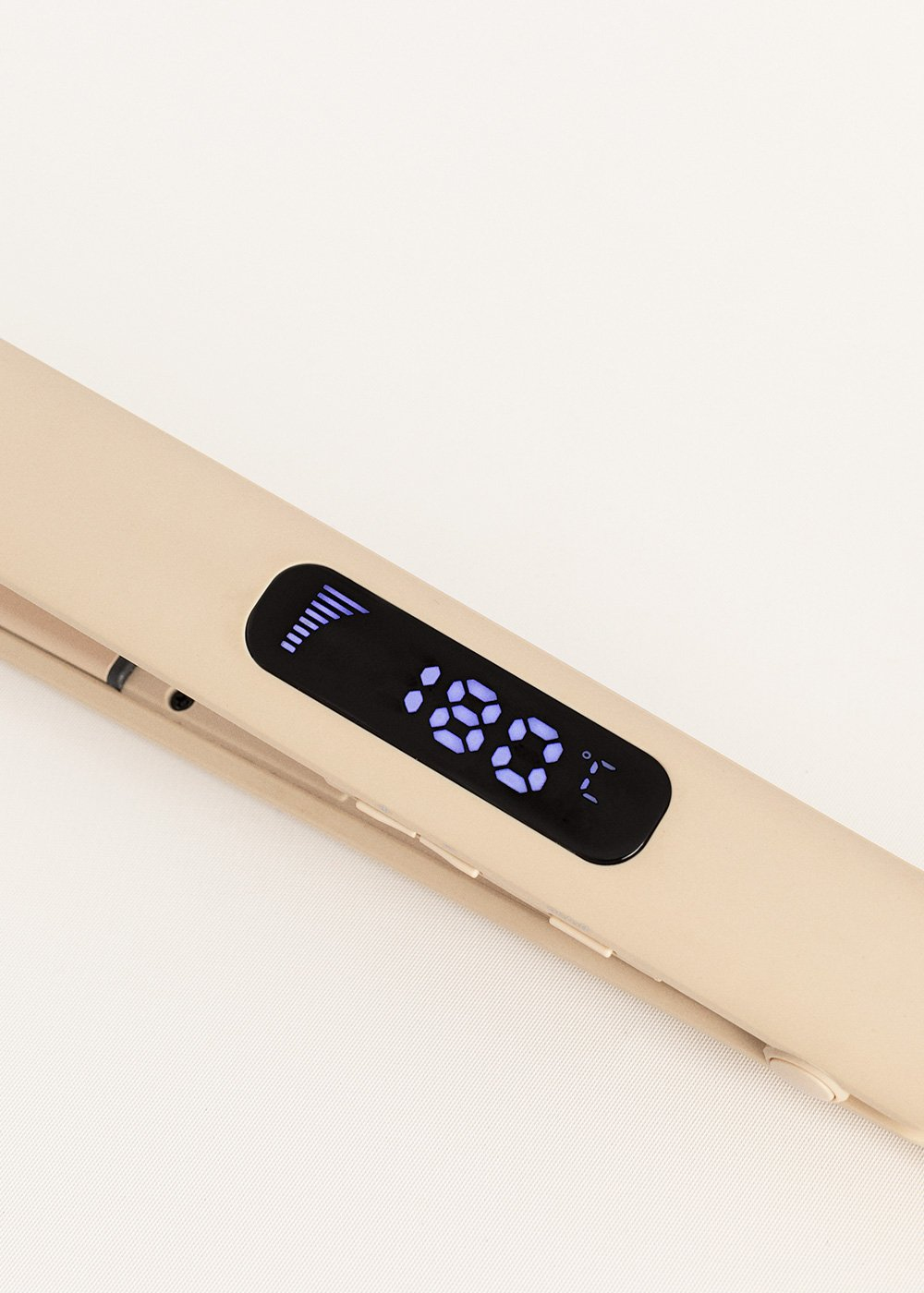Una plancha de pelo beige con pantalla digital que muestra 180°C.