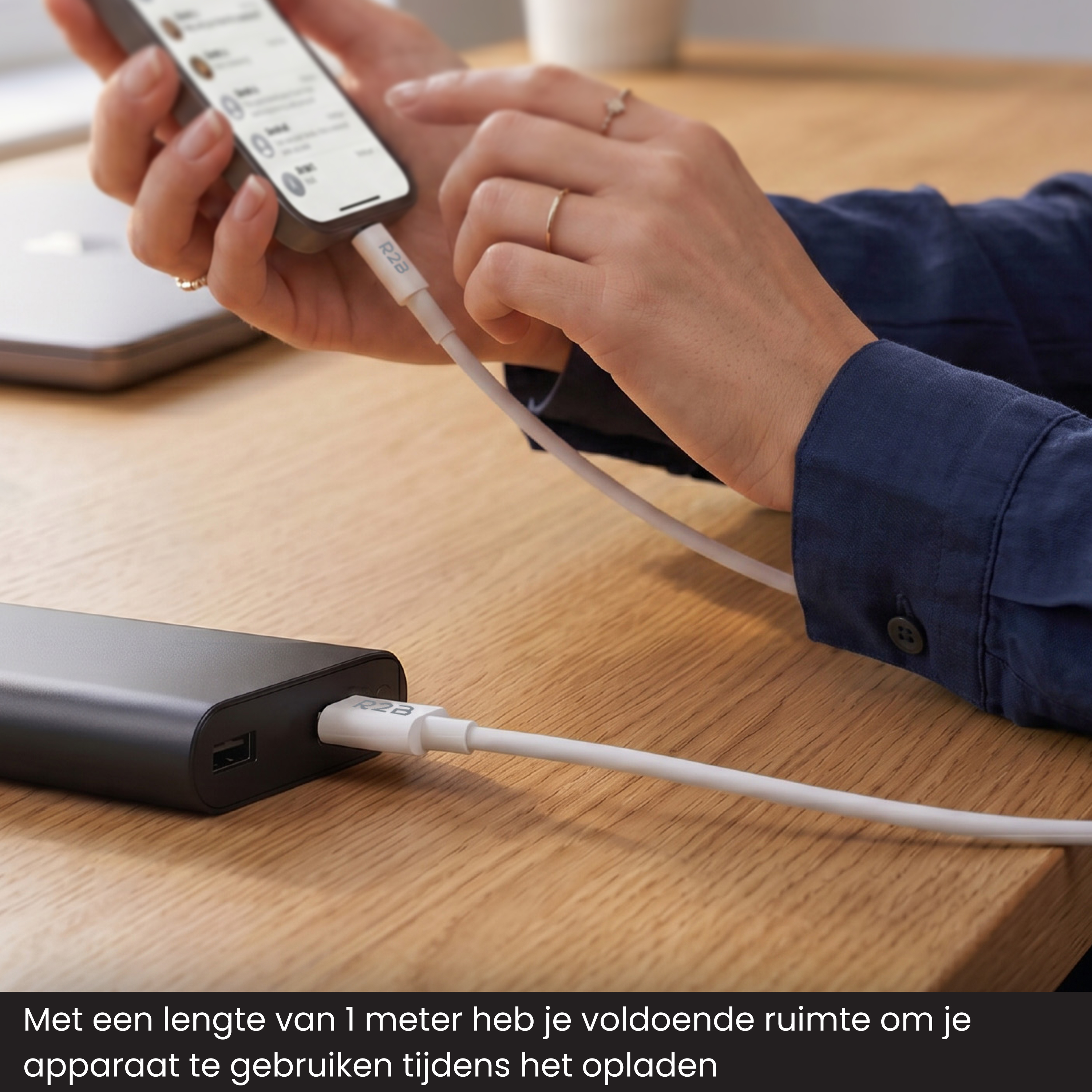 A person charges a smartphone using a black power bank device.
