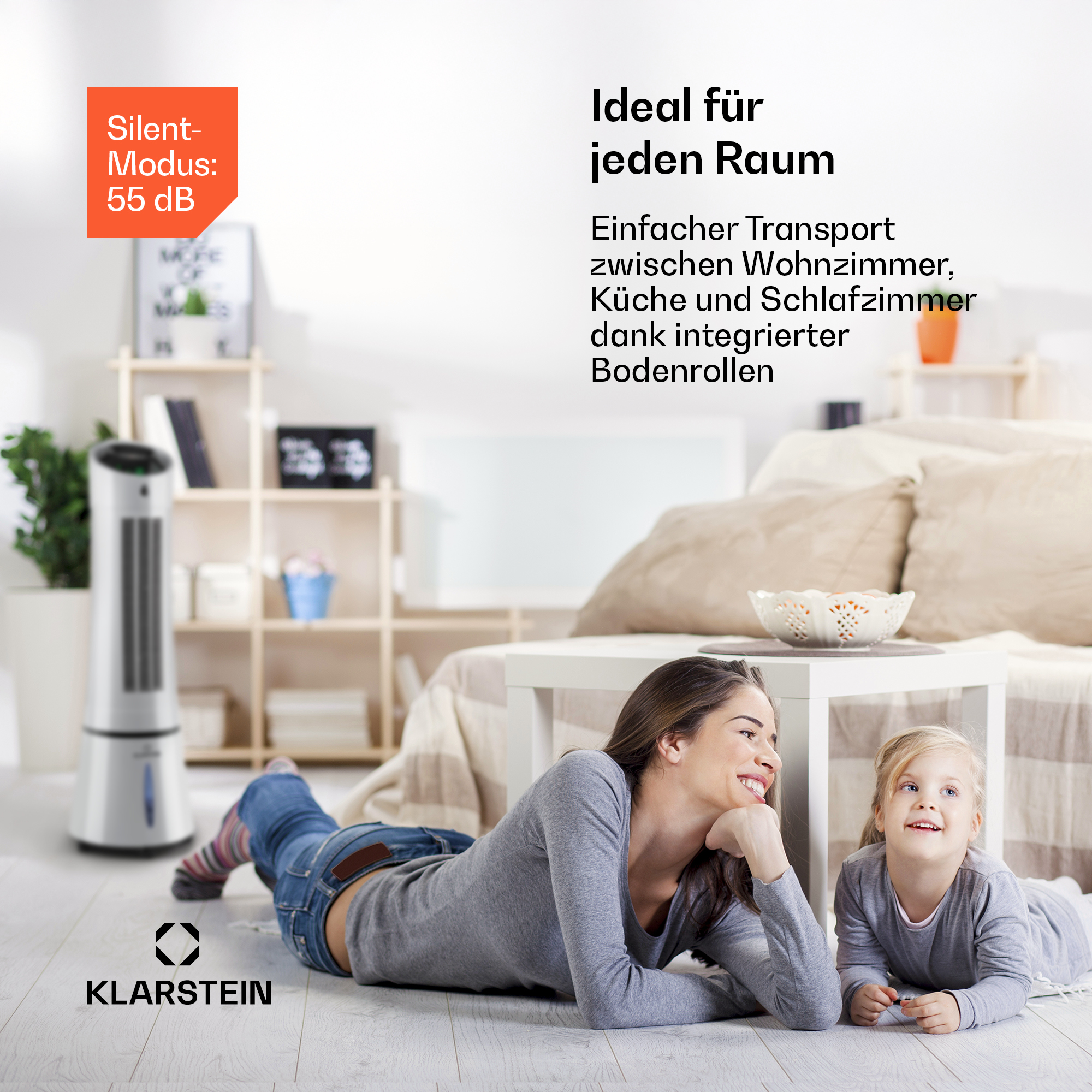 Mutter und Kind liegen auf dem Boden vor einem Turmventilator und einem Regal.