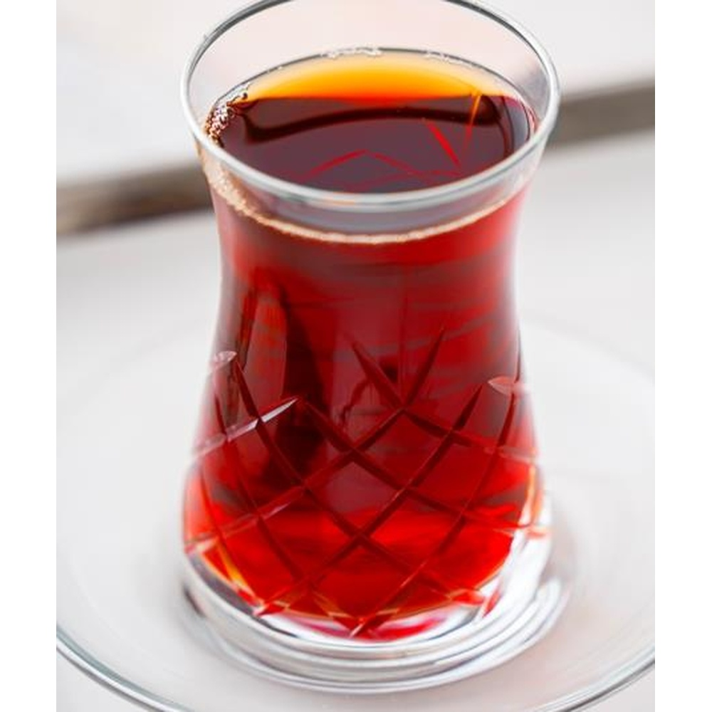 Camında ince desenler bulunan, koyu, aromatik bir bardak çay.