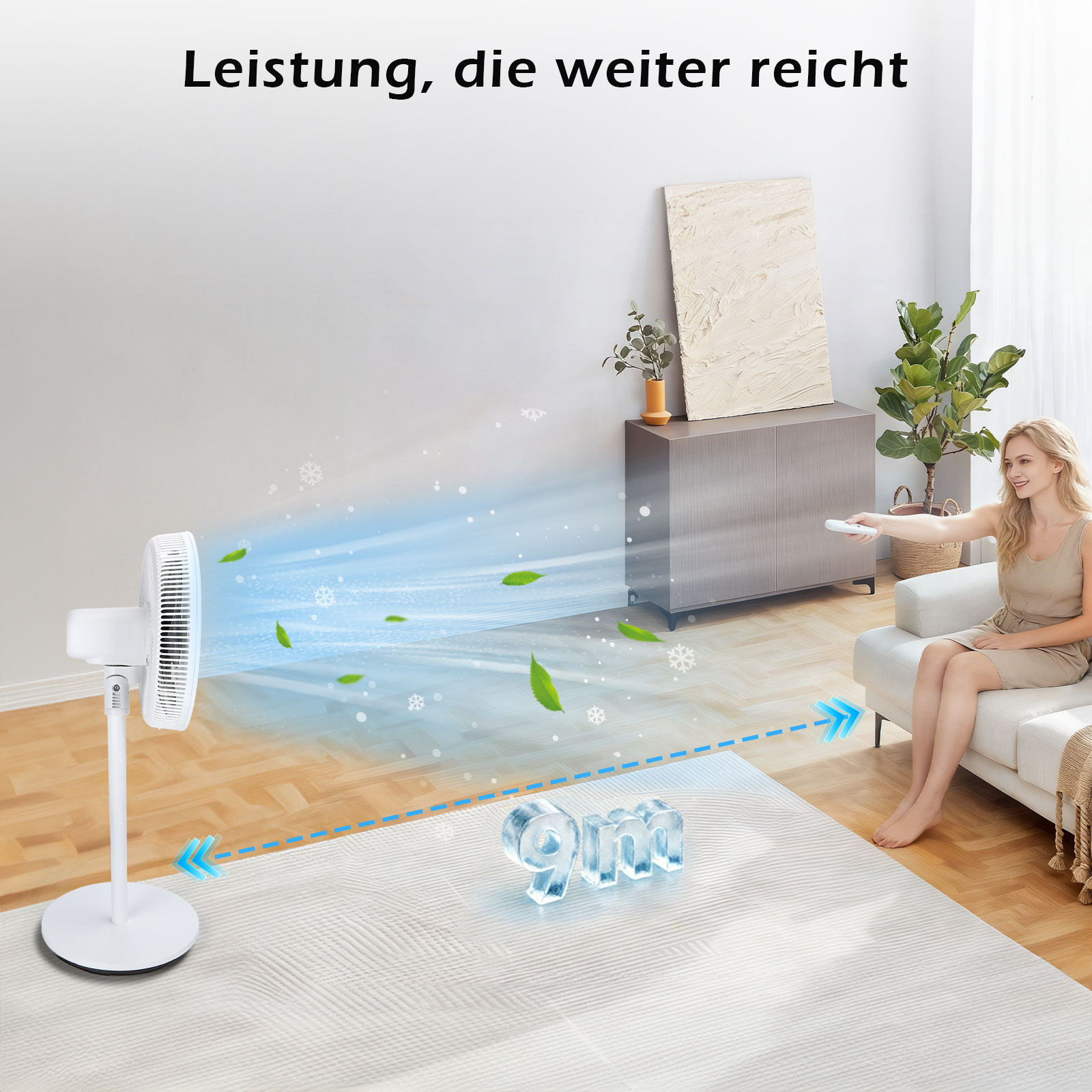 Ein weißer Ventilator bläst Luft und Blätter. Eine Frau sitzt auf einem Sofa.