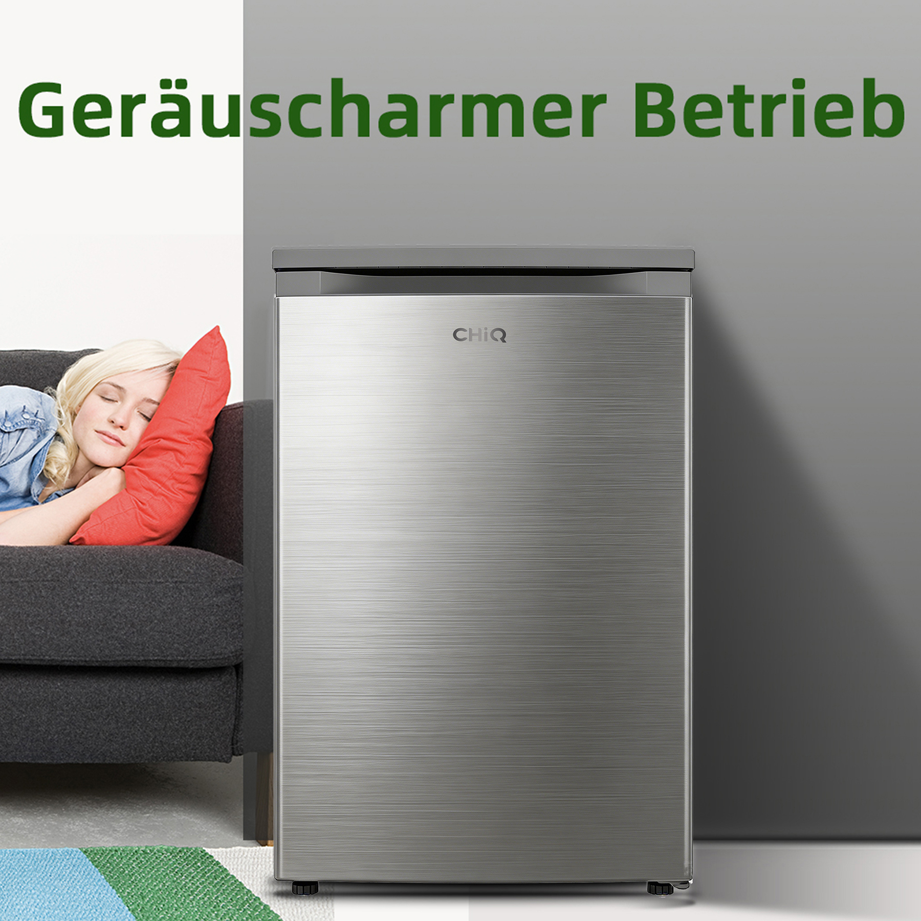 Eine Frau schläft auf einem Sofa neben einem silbernen Kühlschrank.