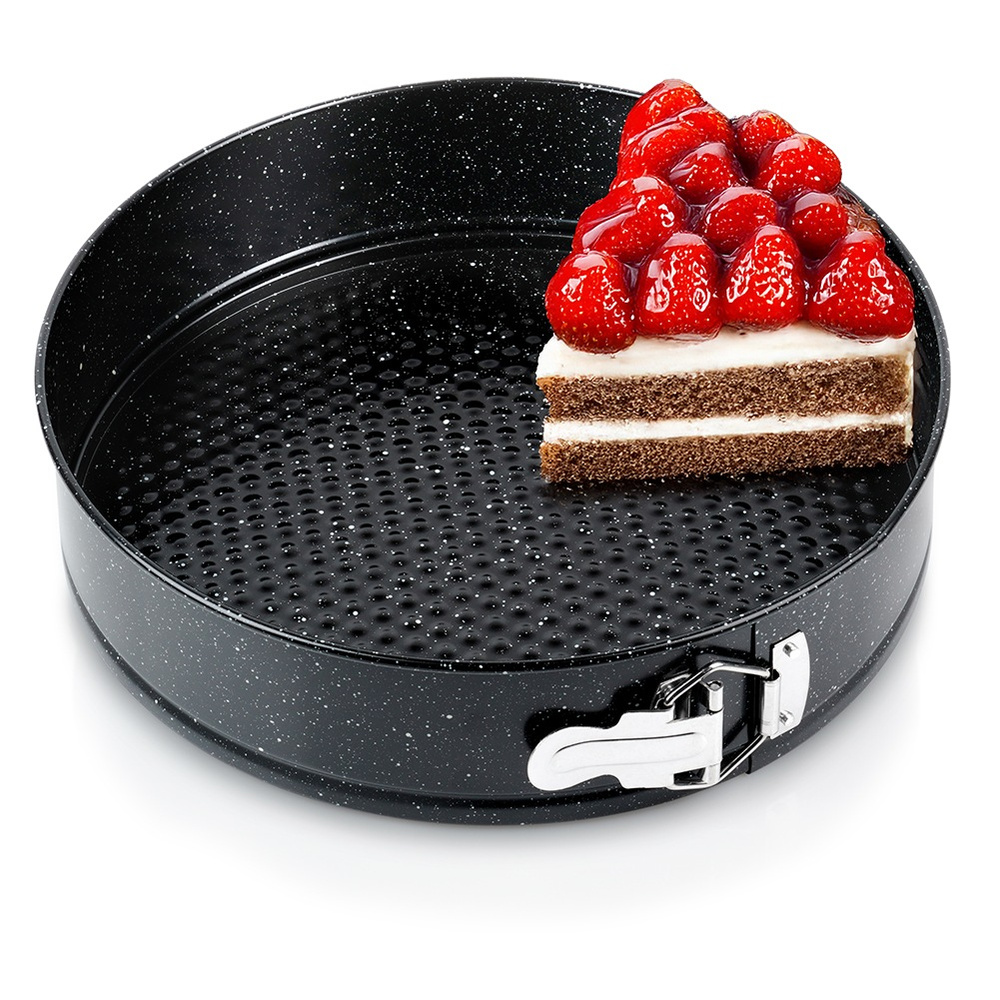 Ein Kuchenstück mit Erdbeeren in einer schwarzen Springform.