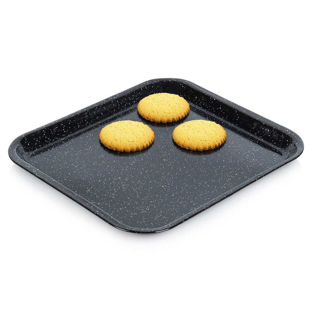 Drei Kekse auf einem rechteckigen, dunklen Backblech mit weißen Sprenkeln.
