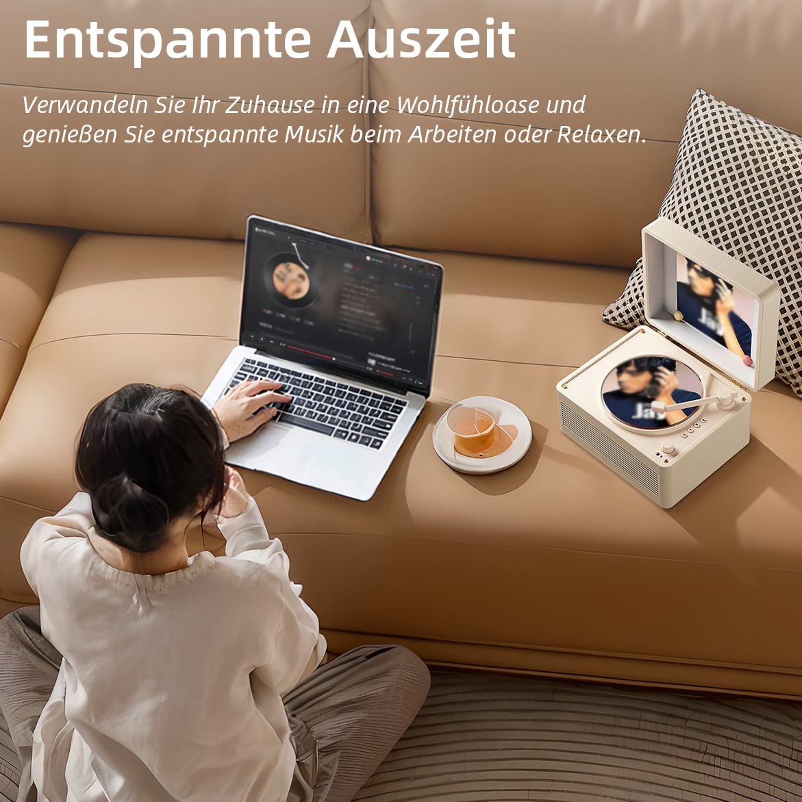 Frau sitzt auf dem Boden, hört Musik über Kopfhörer, Laptop und Plattenspieler auf Sofa.