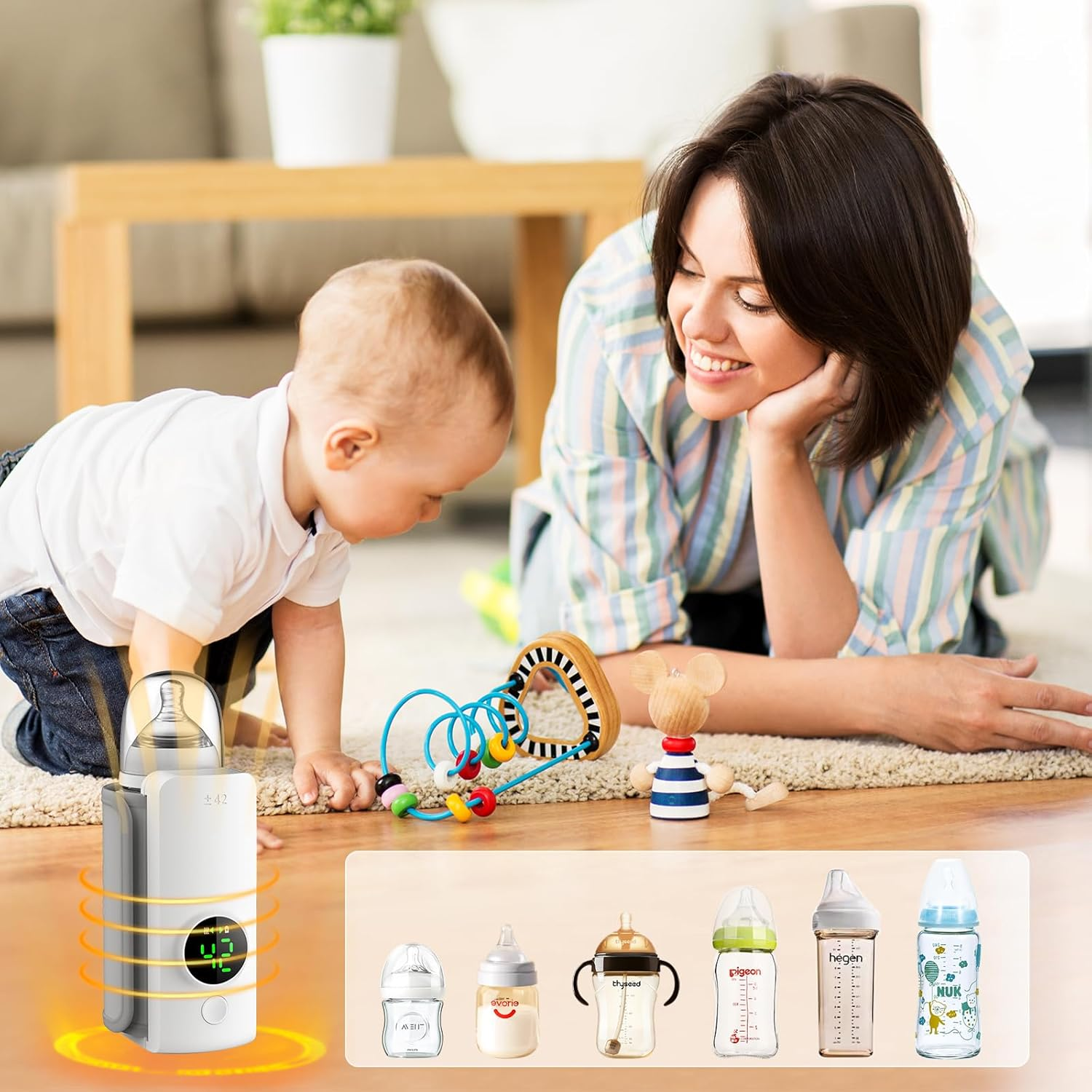 Ein Baby spielt mit Spielzeug, eine Frau schaut zu. Ein Flaschenwärmer ist vorne.