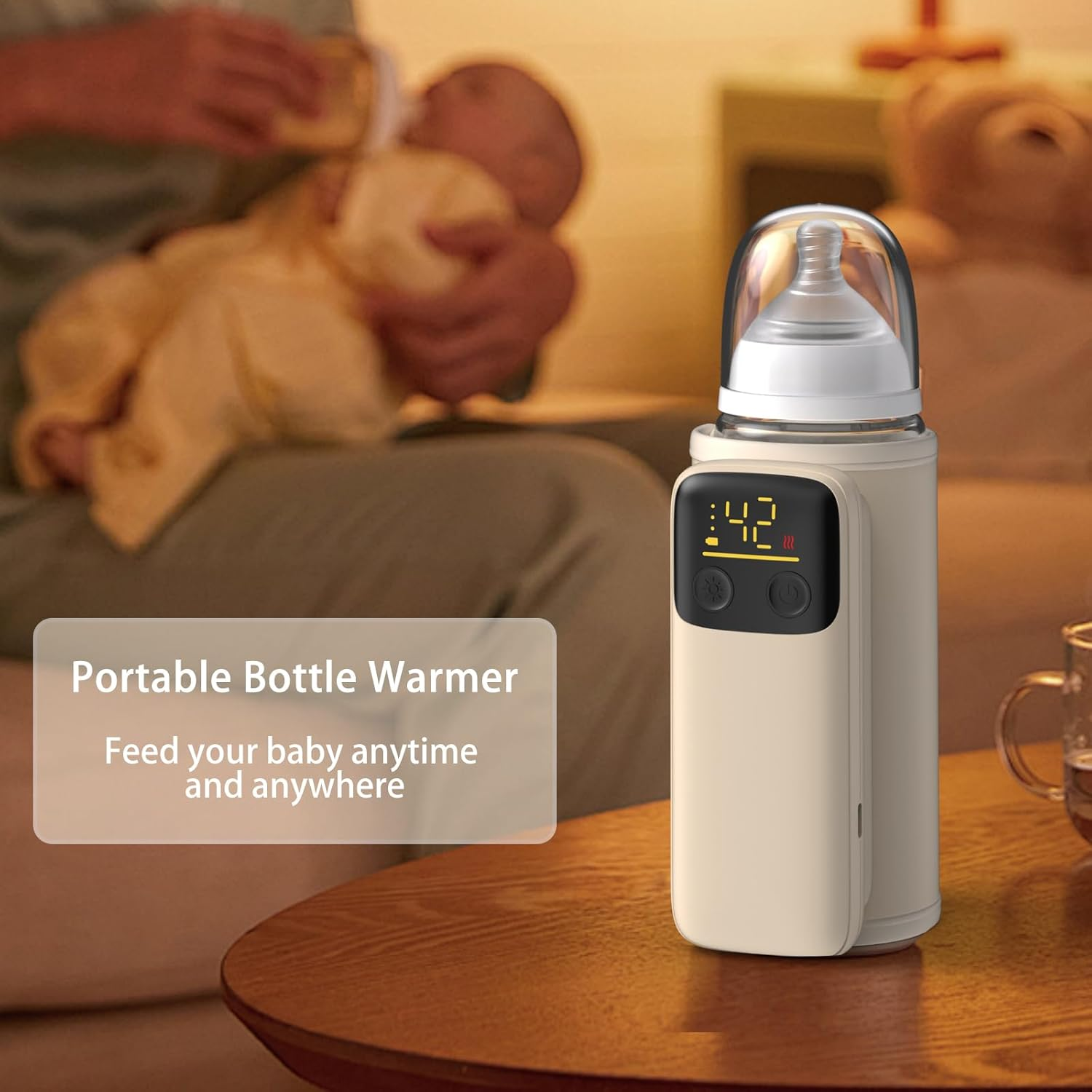 Ein Babyflaschenwärmer mit digitaler Anzeige steht auf einem Holztisch. Im Hintergrund hält eine Person ein Baby.