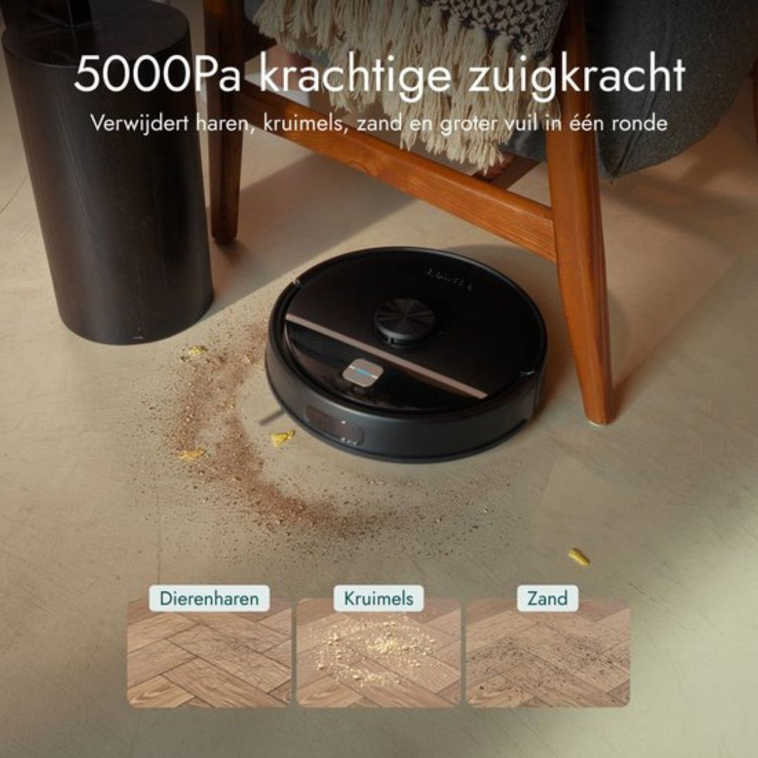 A black robot vacuum cleans a wood floor of pet hair, crumbs, and sand.