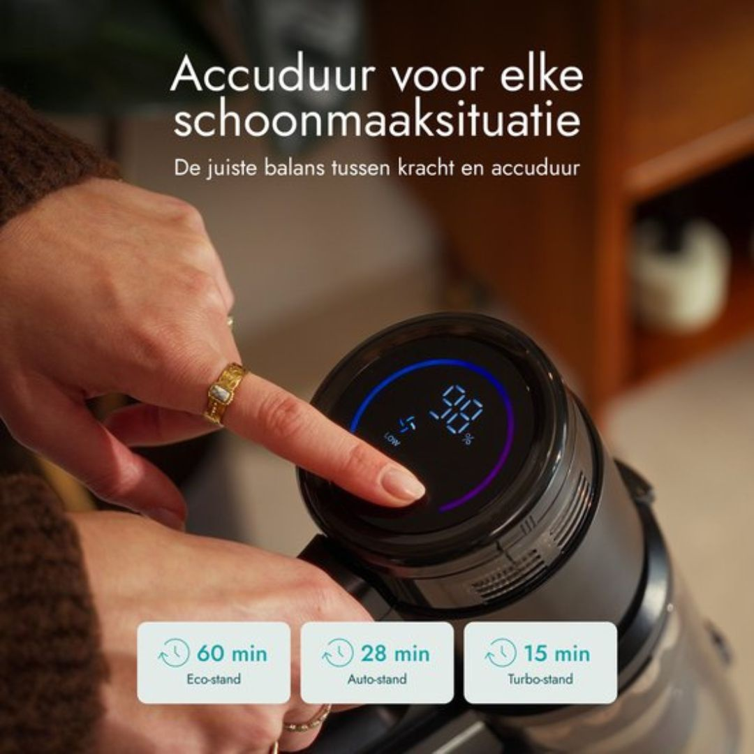 Primo piano di una mano che utilizza un aspirapolvere. Lo schermo mostra il 98% di batteria.