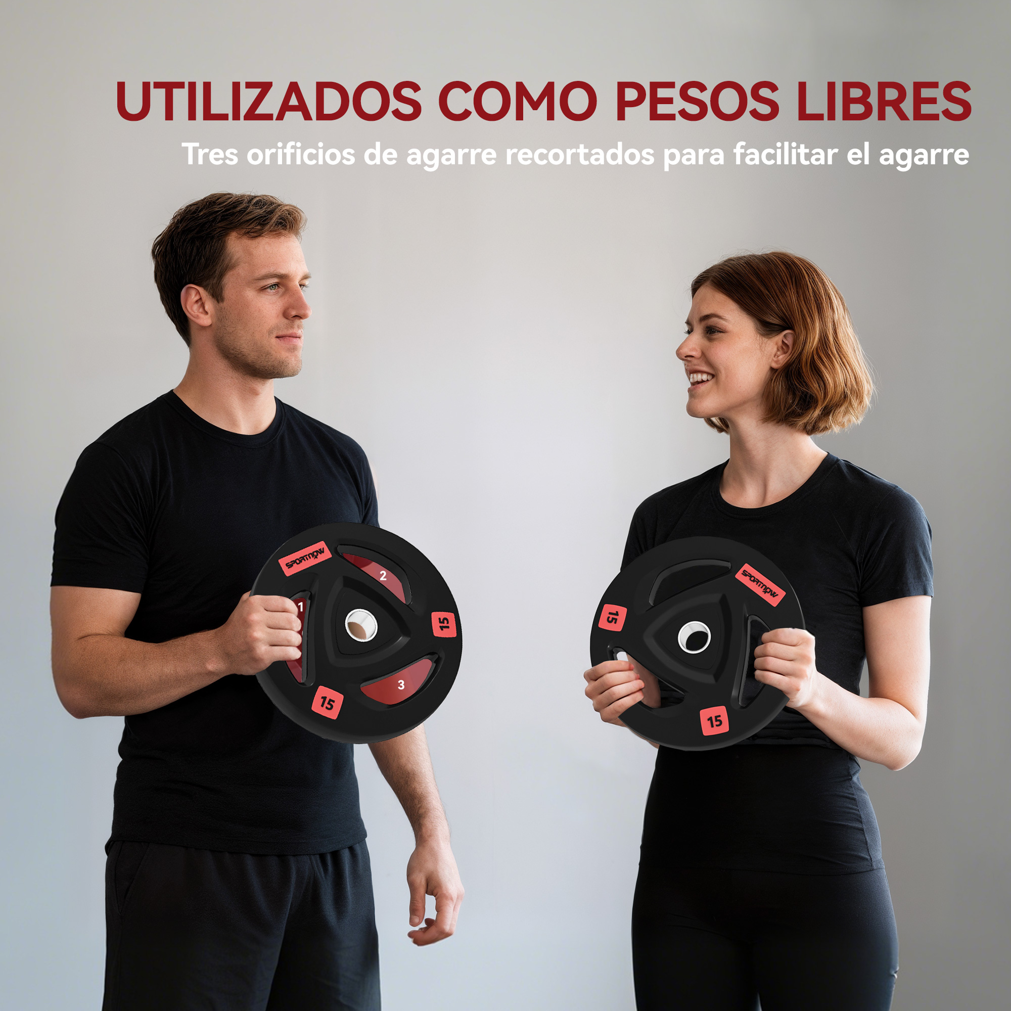 Un hombre y una mujer sostienen discos de pesas negros con detalles rojos.