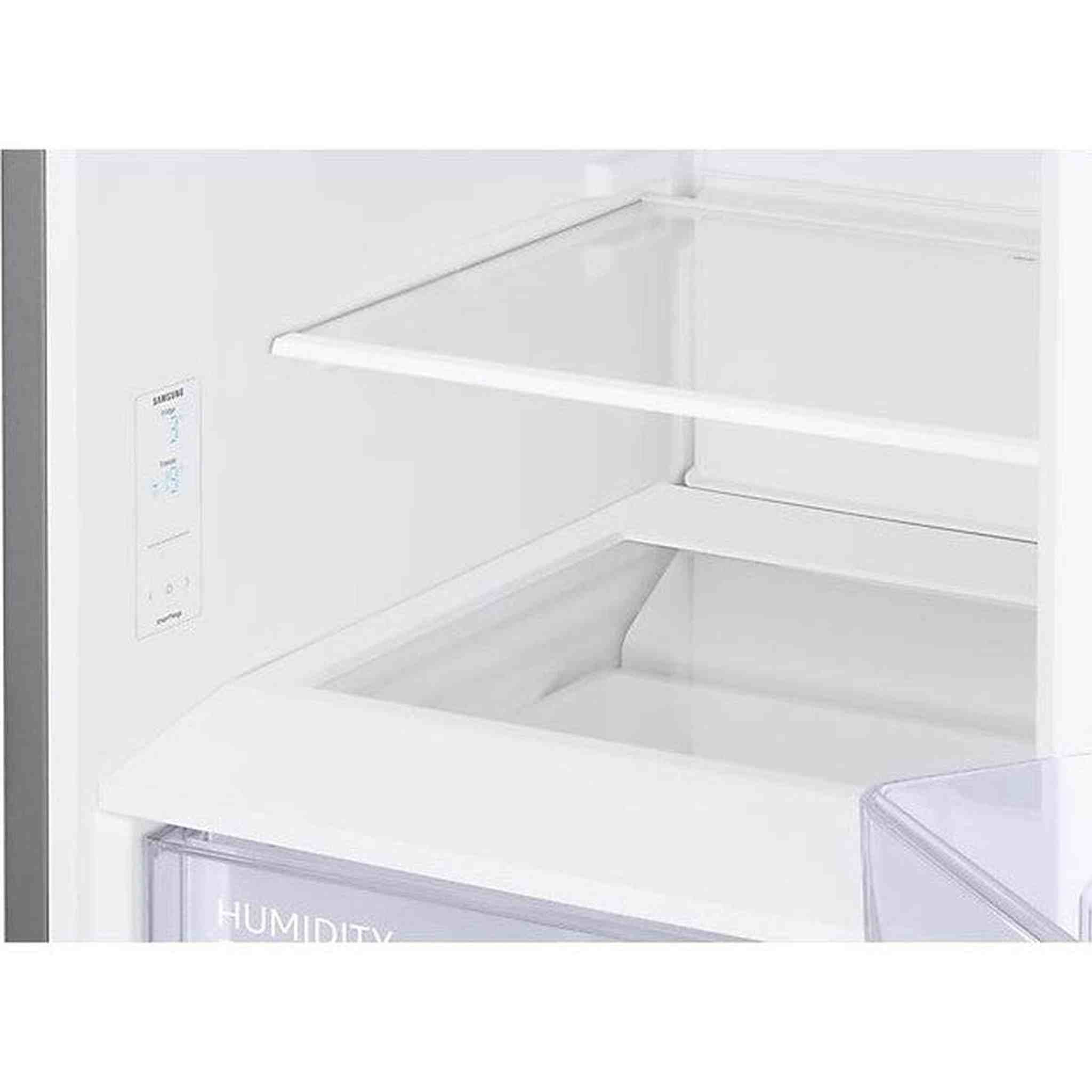 Vista interna di un frigorifero bianco con ripiano e controlli digitali.