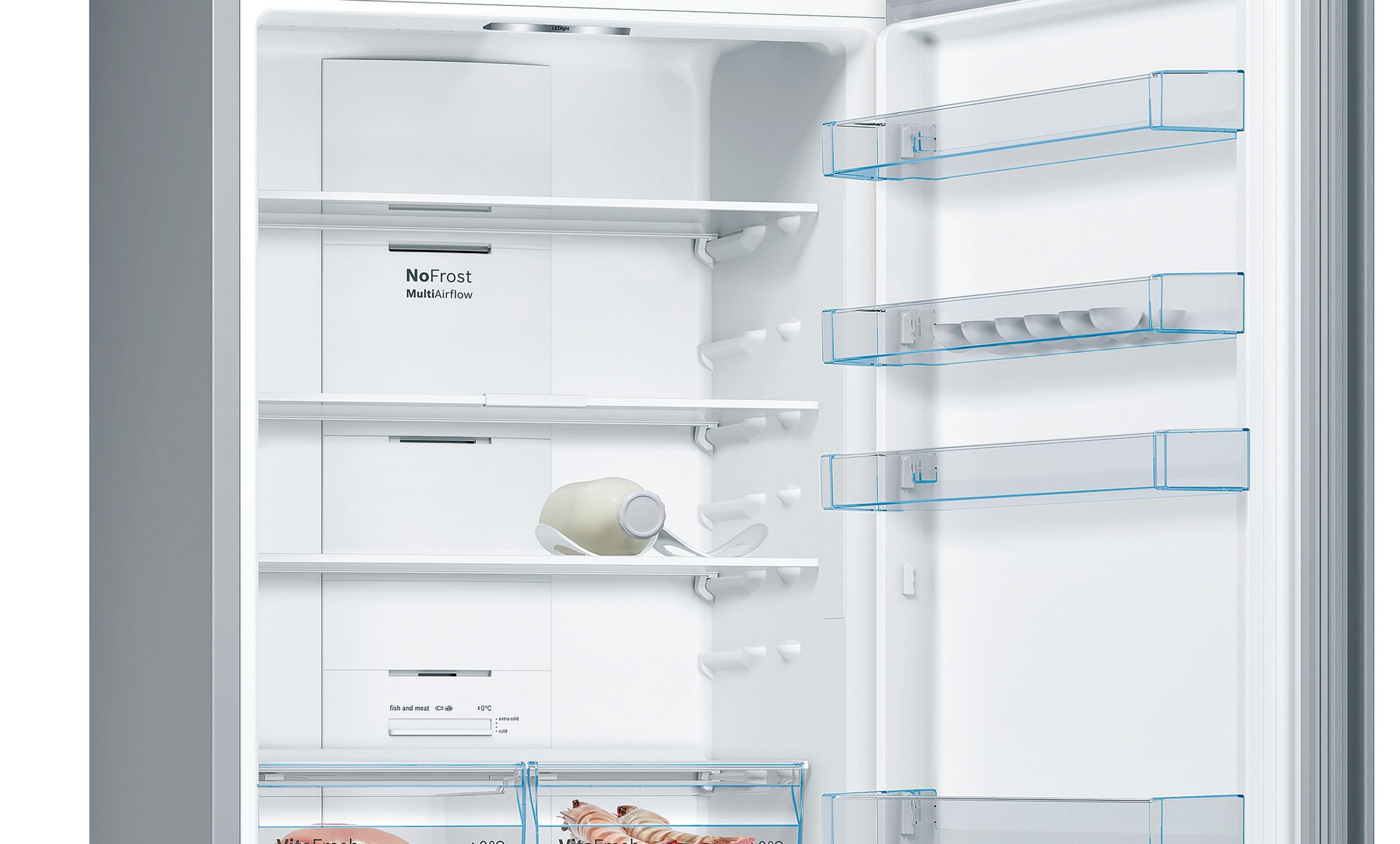 Offener Kühlschrank-Innenraum mit Einlegeböden, Schubladen und einer Milchflasche auf einem Regal.