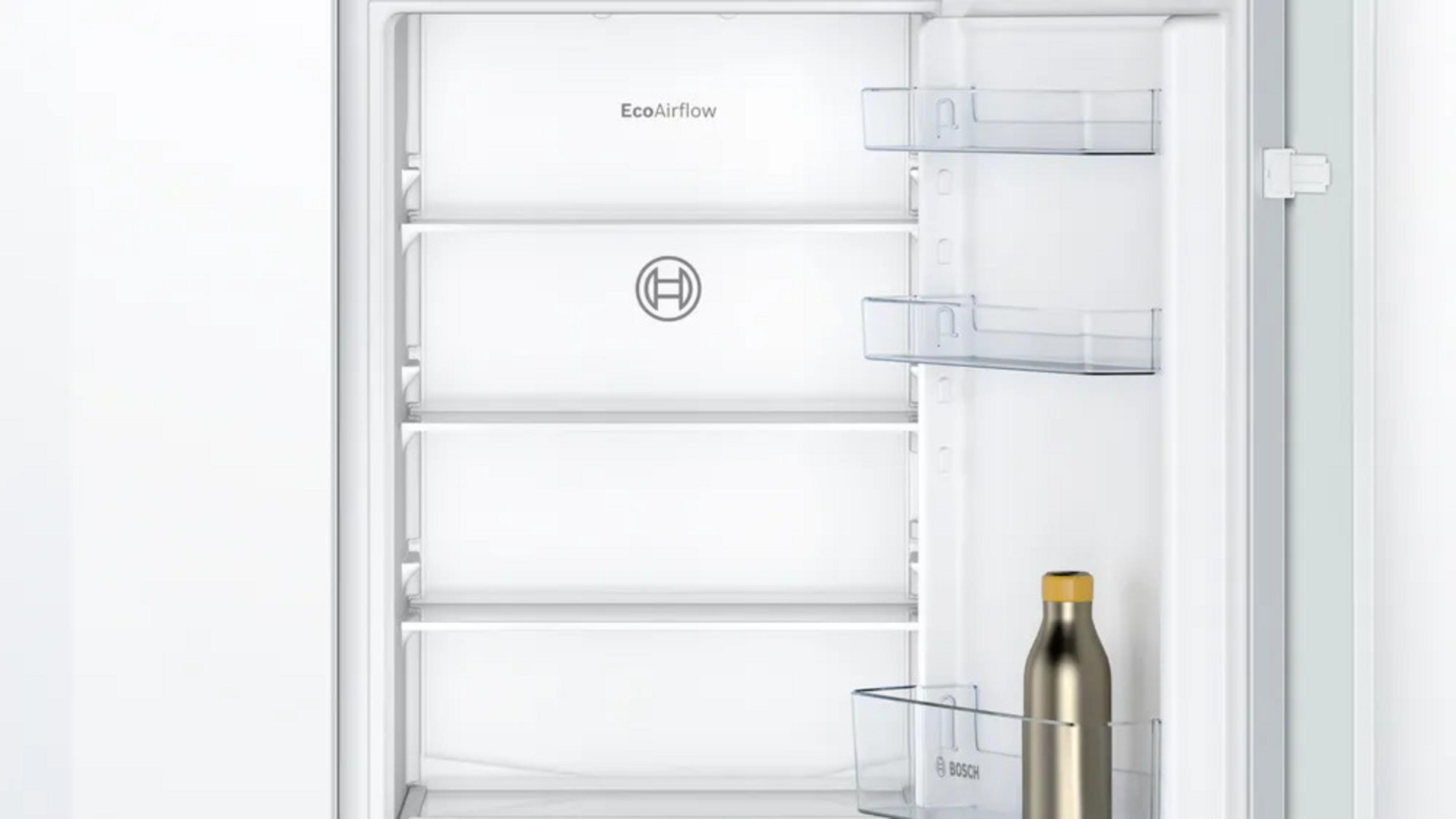 Innenansicht eines weißen Kühlschranks mit Glasregalen und einer Flasche.