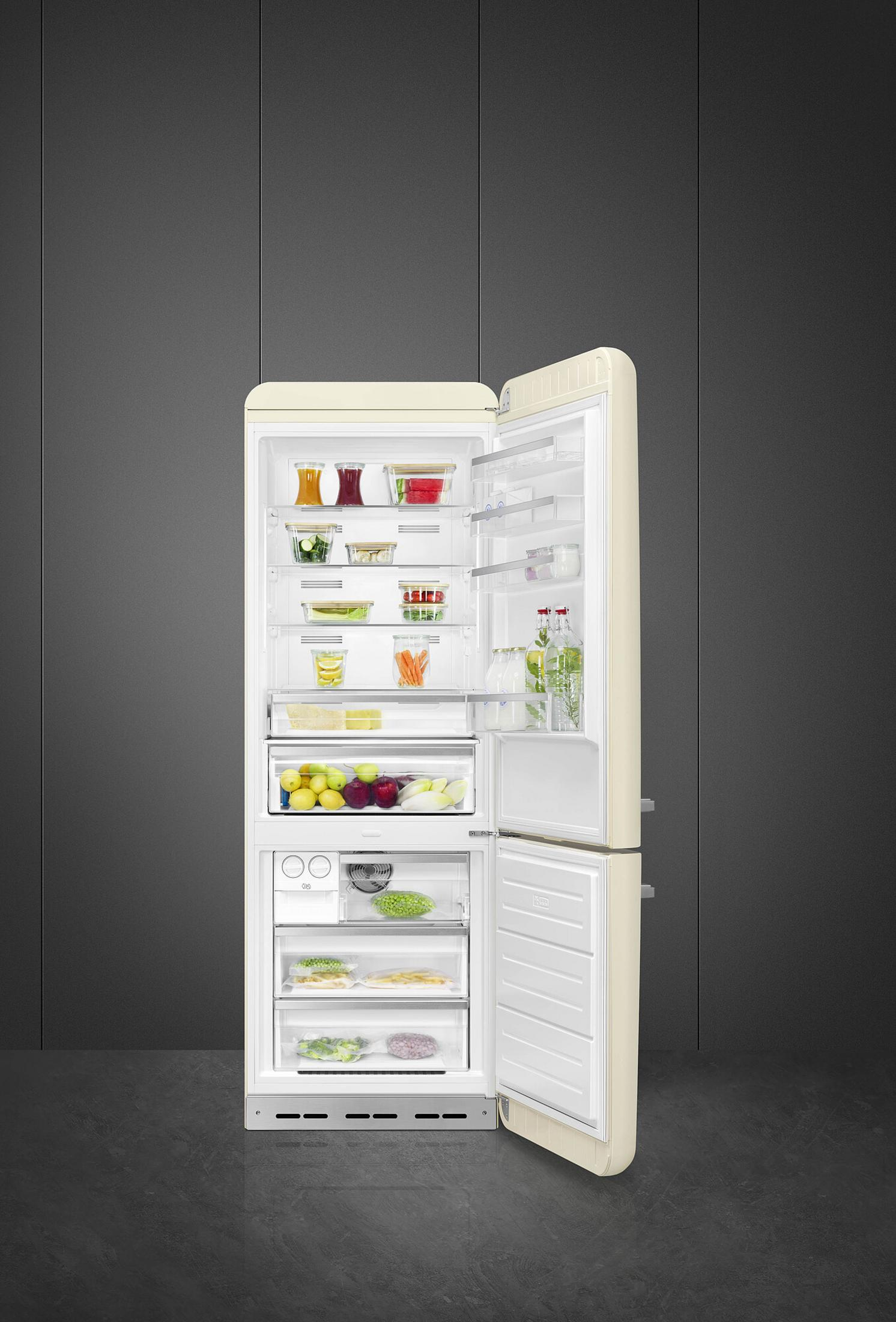 Un refrigerador abierto de color crema lleno de alimentos.