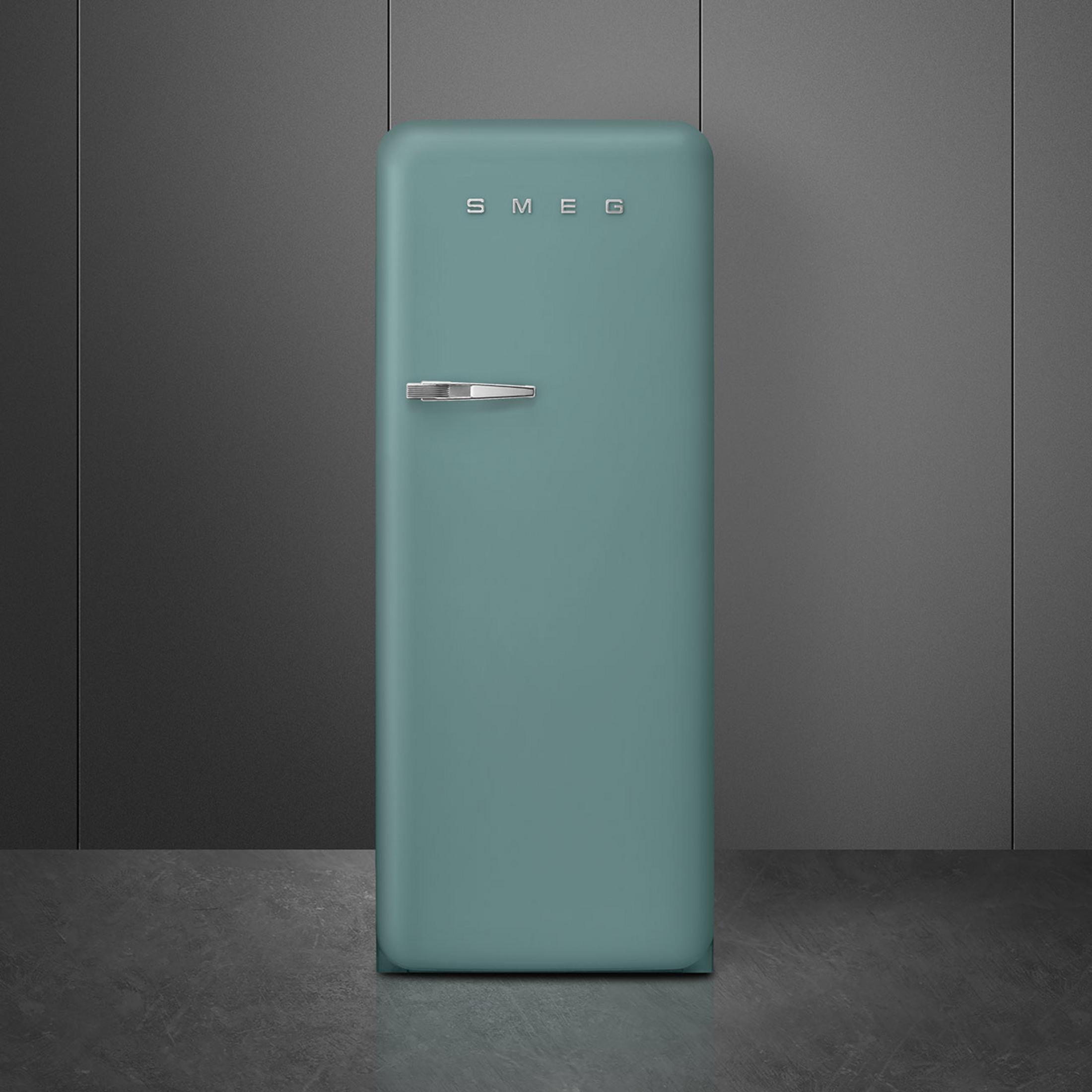 Ein türkisfarbener Smeg-Kühlschrank mit silbernem Griff vor einem dunklen Hintergrund.