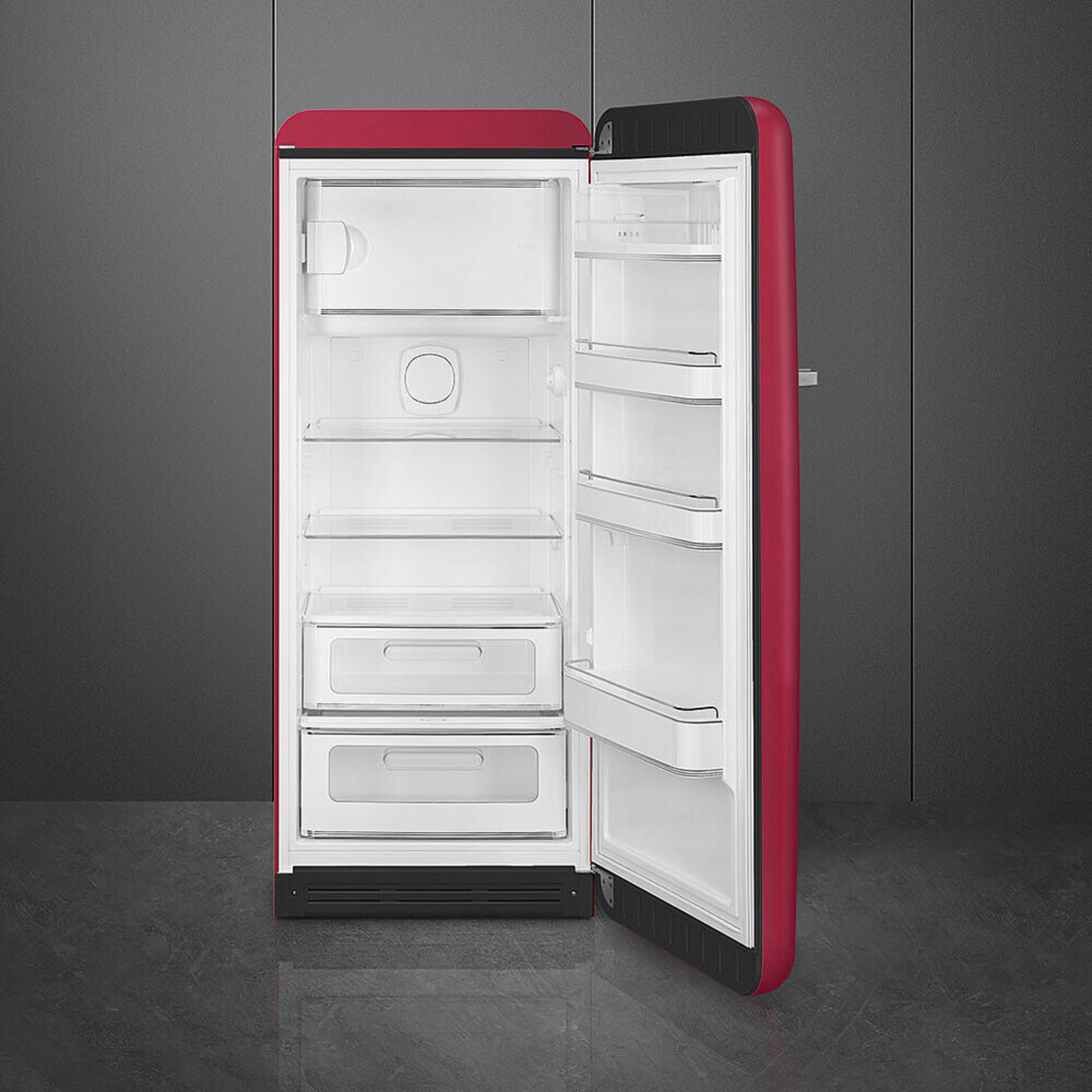 Un frigorifero rosso con porta aperta, che mostra ripiani e cassetti.
