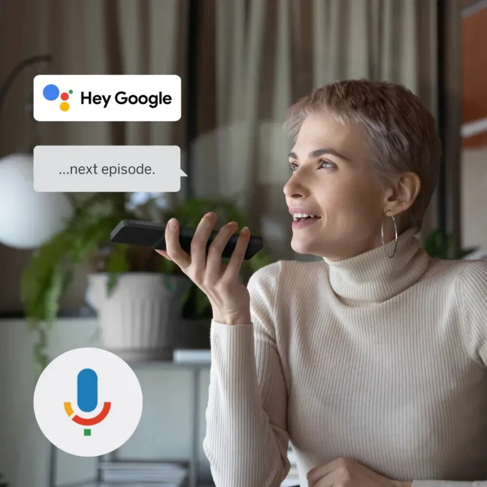 Una mujer habla a un teléfono con "Hey Google" mostrado.