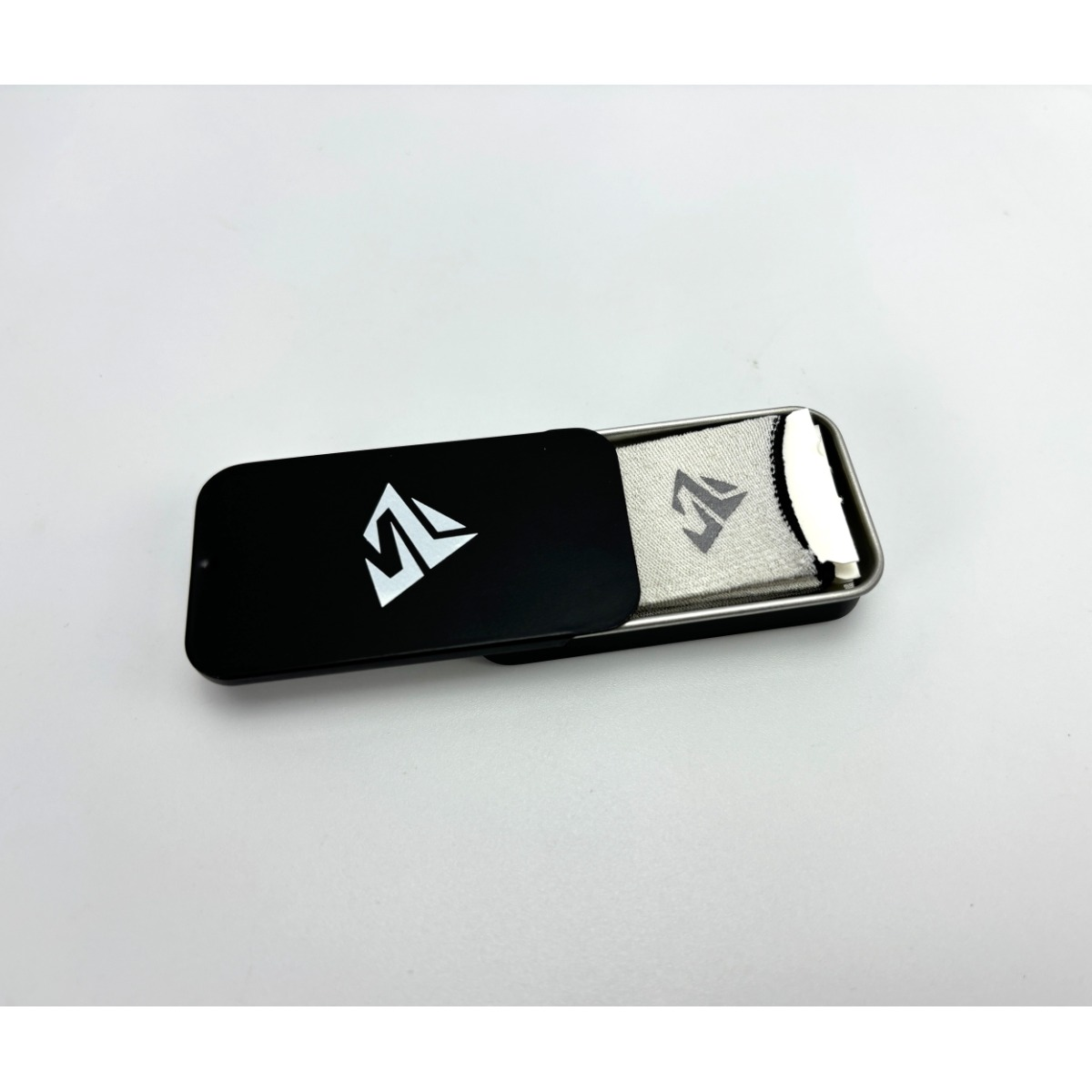 Una custodia in metallo nero con interno in rete argentata, con logo bianco sul coperchio.