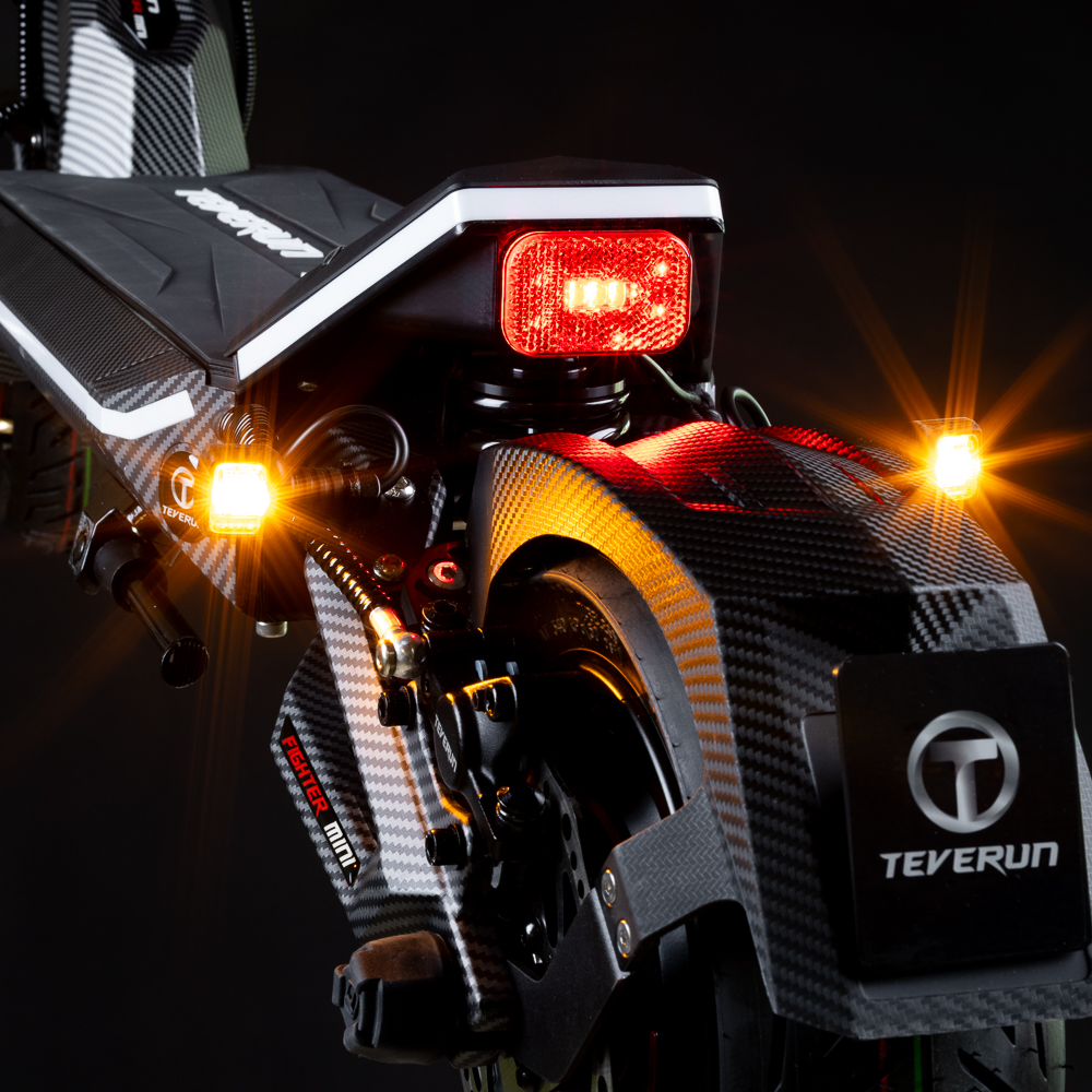 Rückseite eines E-Scooters mit leuchtenden roten Bremslichtern und orangen Blinkern.