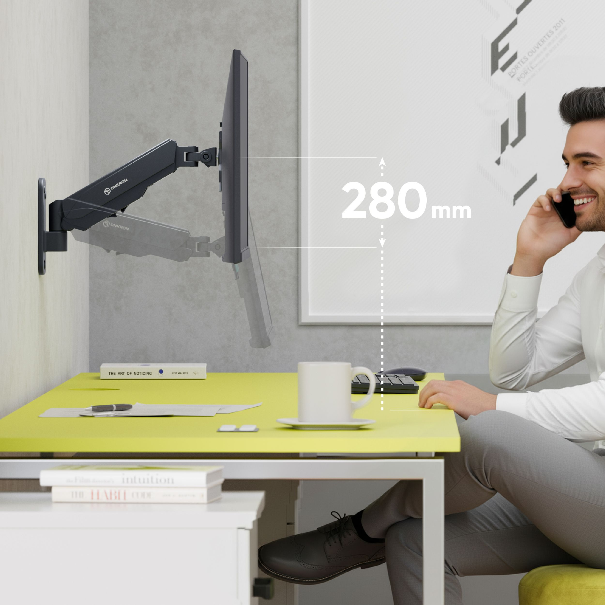 Ein Mann telefoniert an einem Schreibtisch mit einem Monitorarm und einem gelben Tisch.