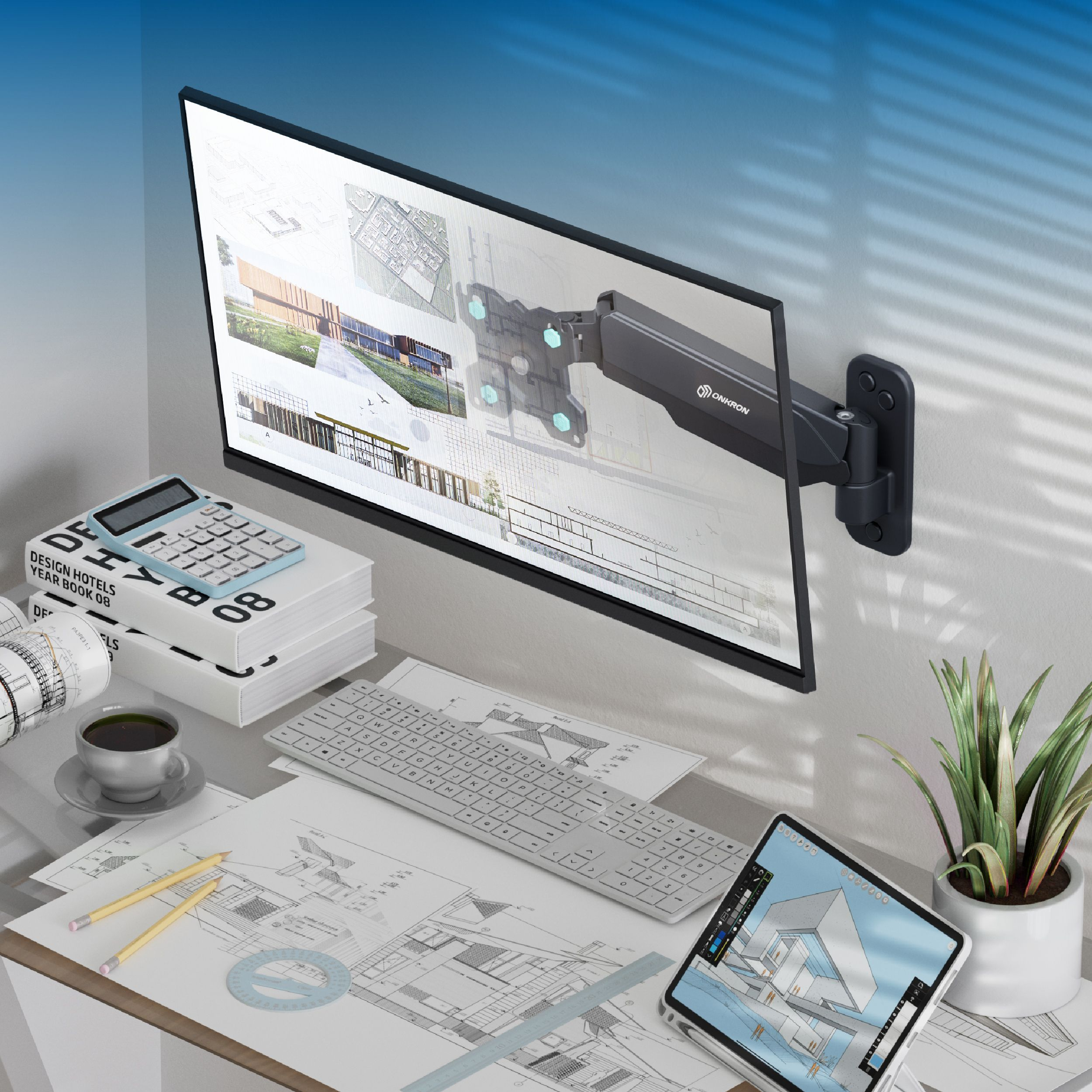 Ein moderner Schreibtisch mit einem Monitor, Tastaturen, Büchern und Architekturplänen.