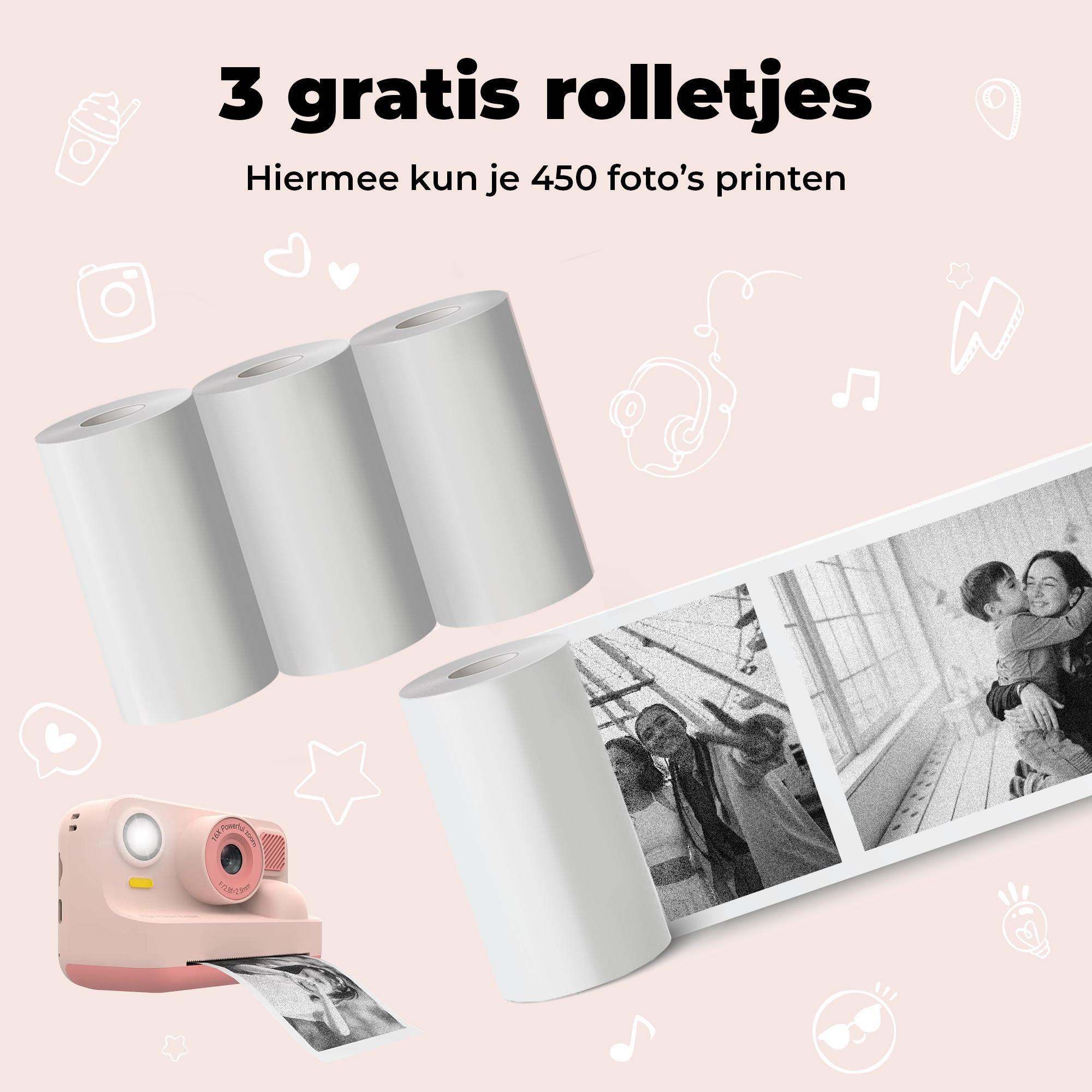 A pink instant camera prints a photo. Three rolls of white paper are beside it.