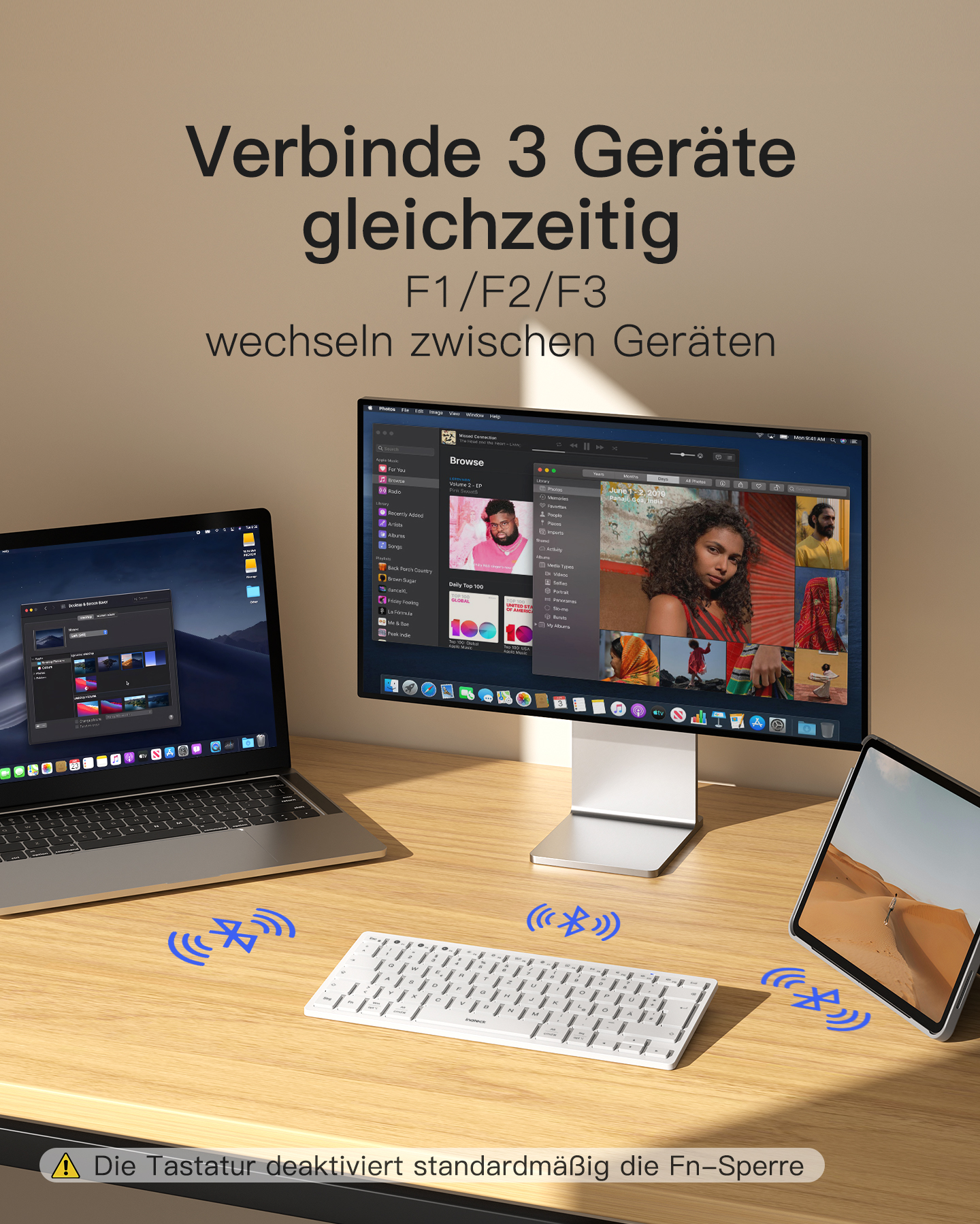 Ein Laptop, Monitor und Tablet auf einem Schreibtisch mit Tastatur.