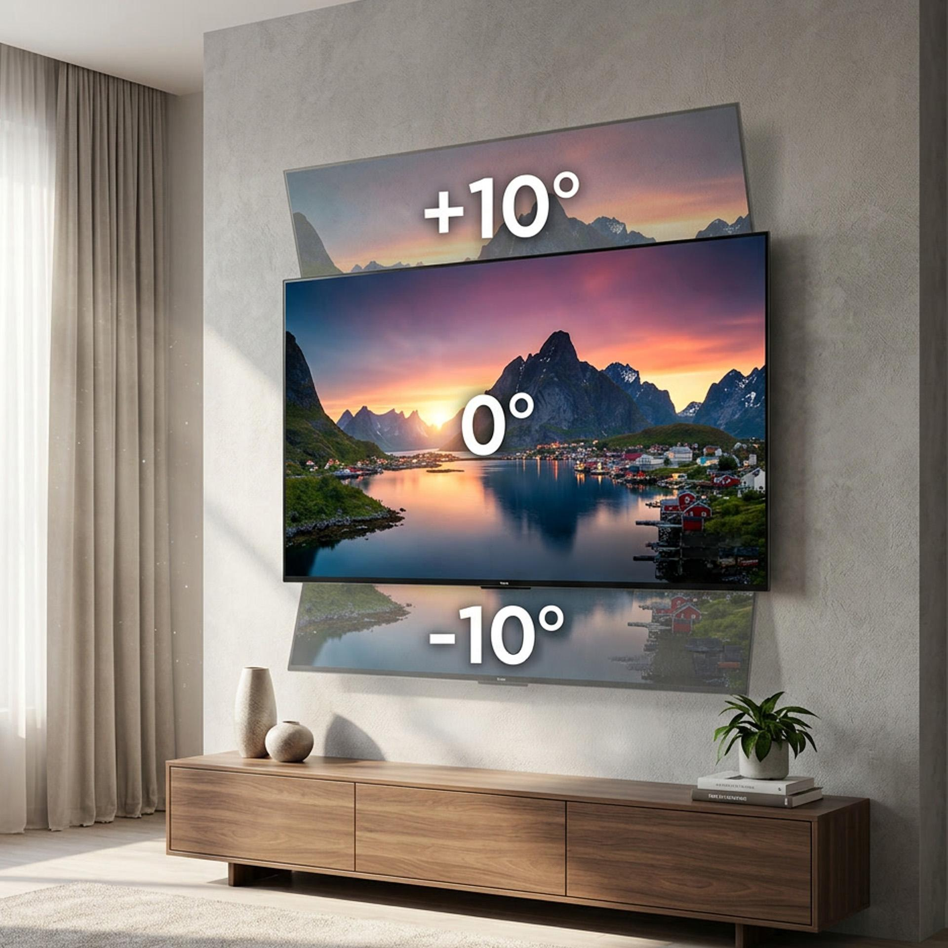 Telewizor wyświetla górski krajobraz z domami nad wodą o zachodzie słońca.