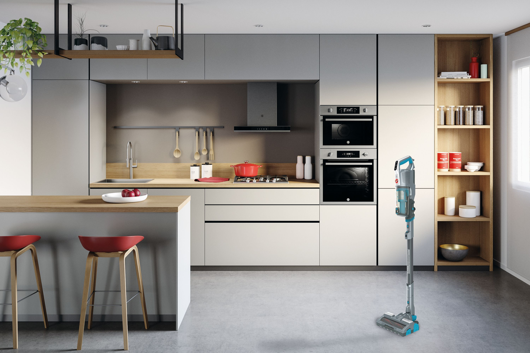 Moderna cucina grigia con isola, sgabelli rossi e aspirapolvere senza fili.