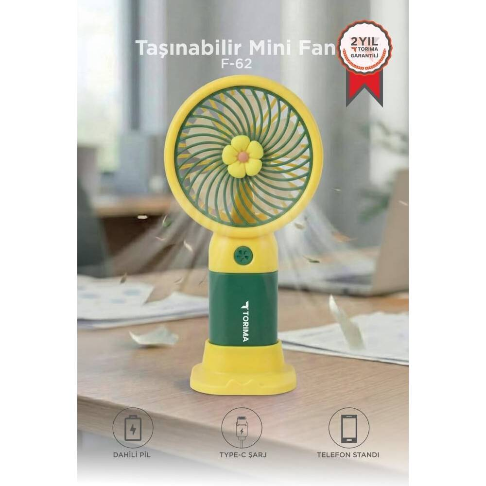 Çiçek desenli sarı ve yeşil mini vantilatör masanın üzerinde duruyor.