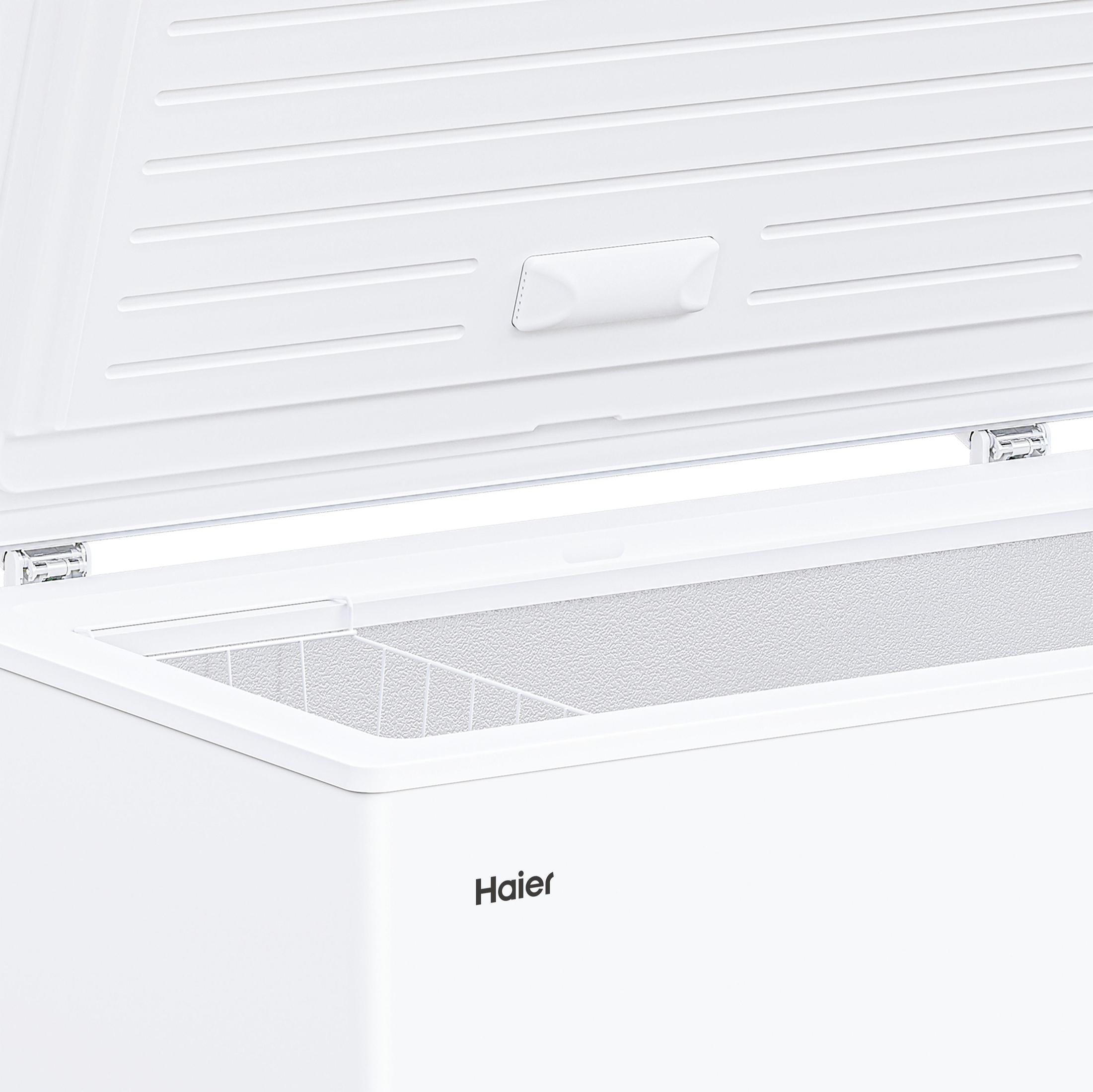 Ein geöffneter weißer Haier-Truhengefrierschrank mit sichtbarem Innenraum und Aufbewahrungskorb.