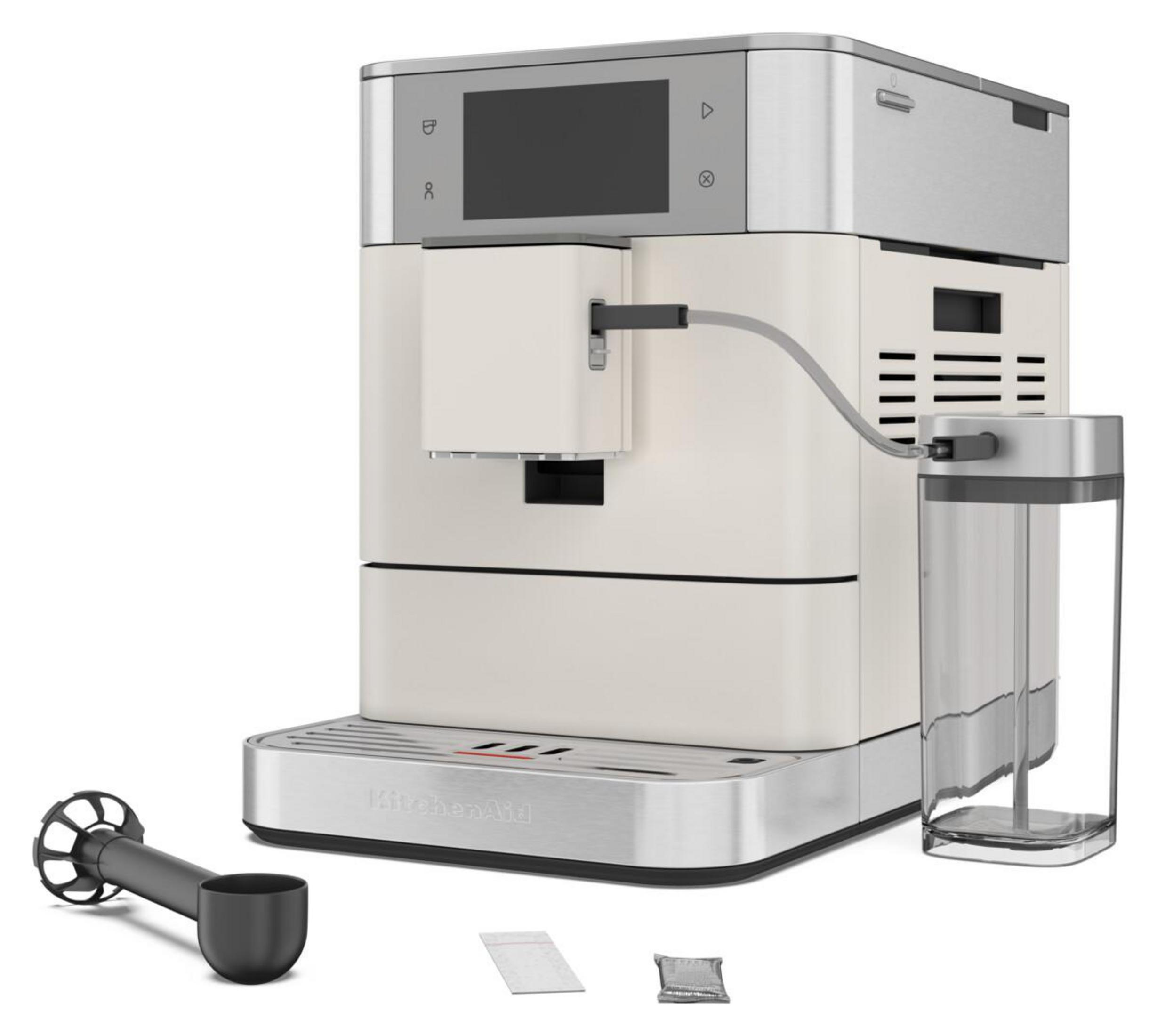 Dijital ekranlı, süt sürahili ve aksesuarlı krem rengi KitchenAid makinesi.