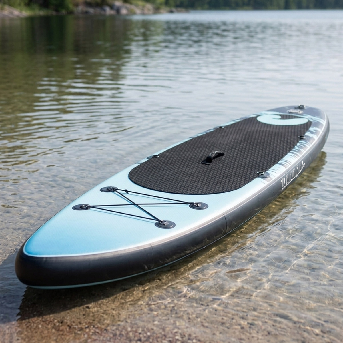 Ein blaues und schwarzes Stand-Up-Paddleboard liegt im flachen Wasser am Ufer.